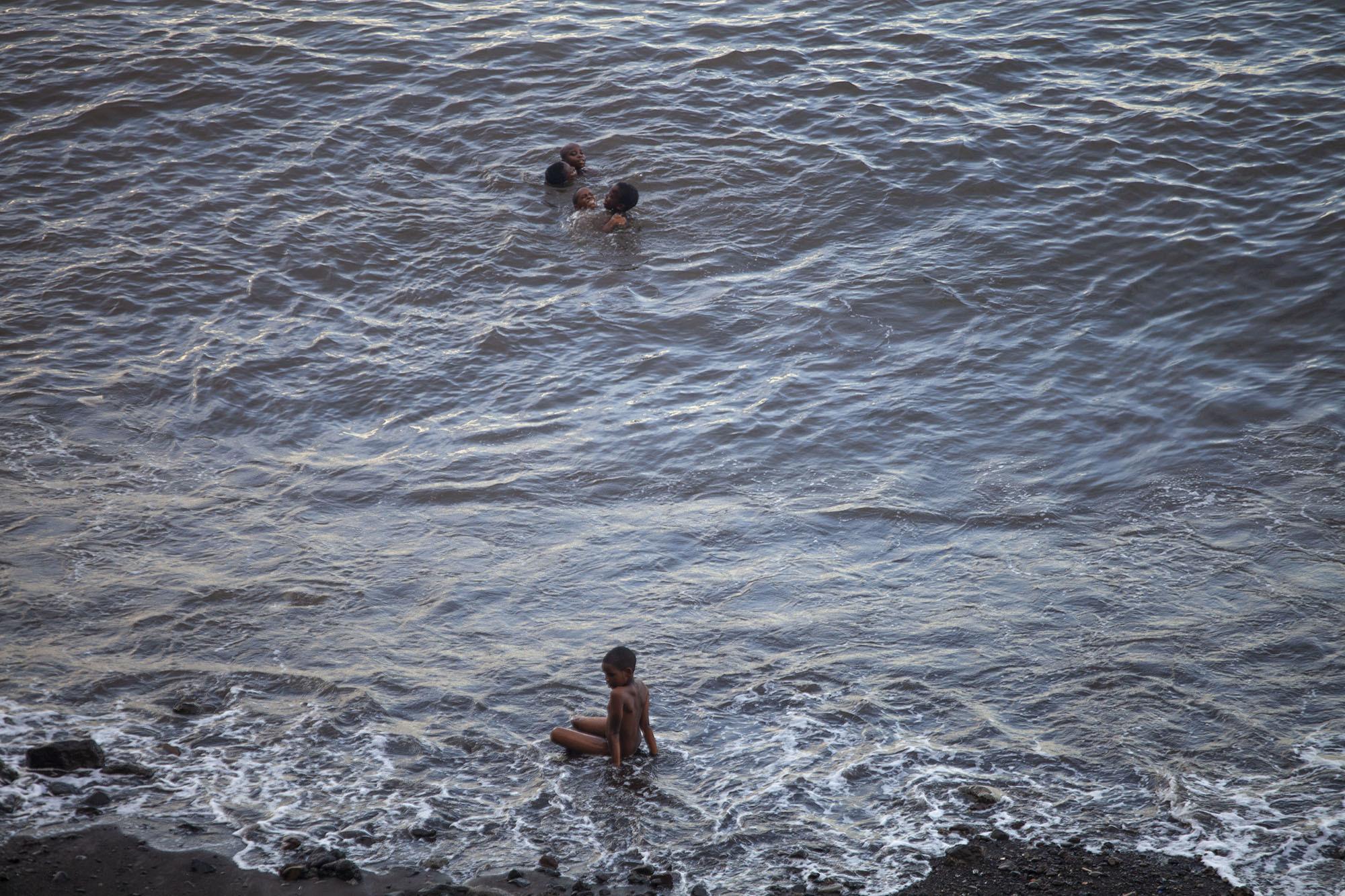 Children swimming ocean at beach in Mutsamudu Anjouan Comoros