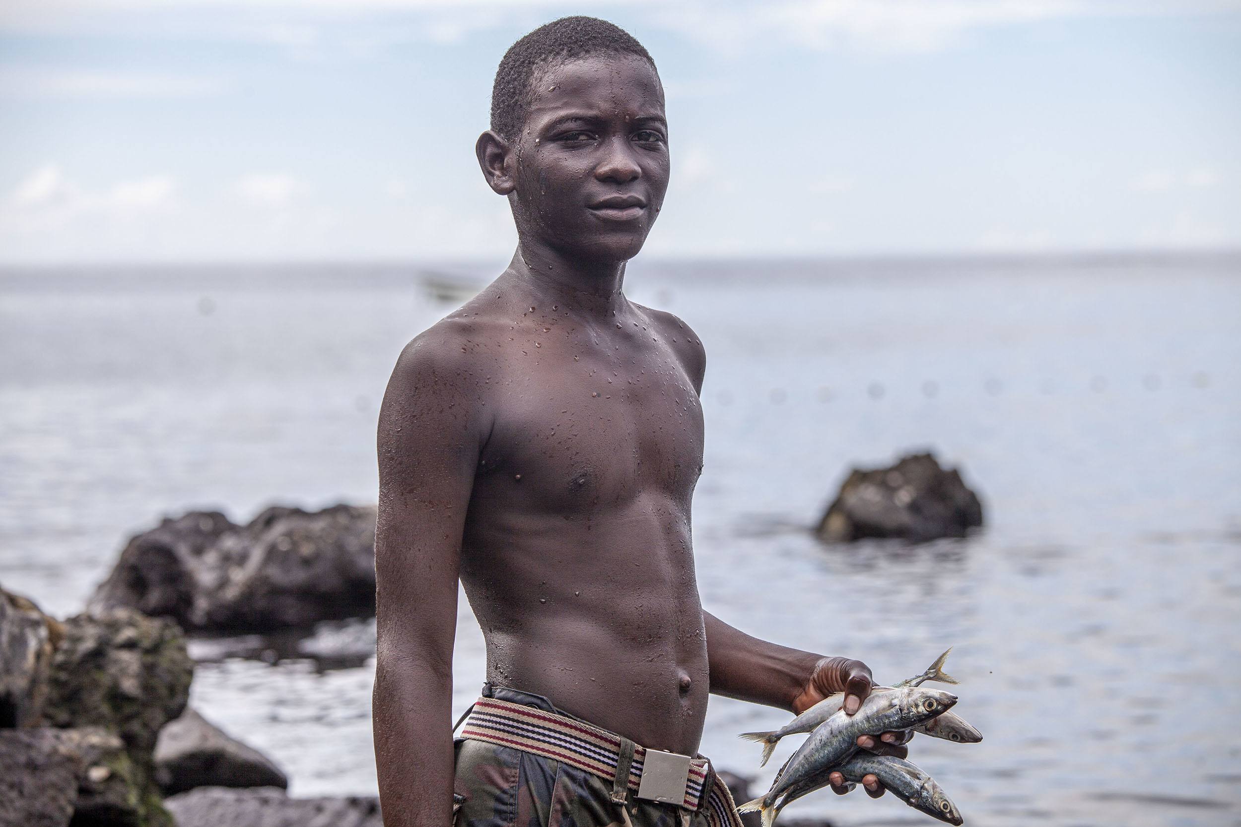 Comorian boy with fish in his hands Moroni Comoros