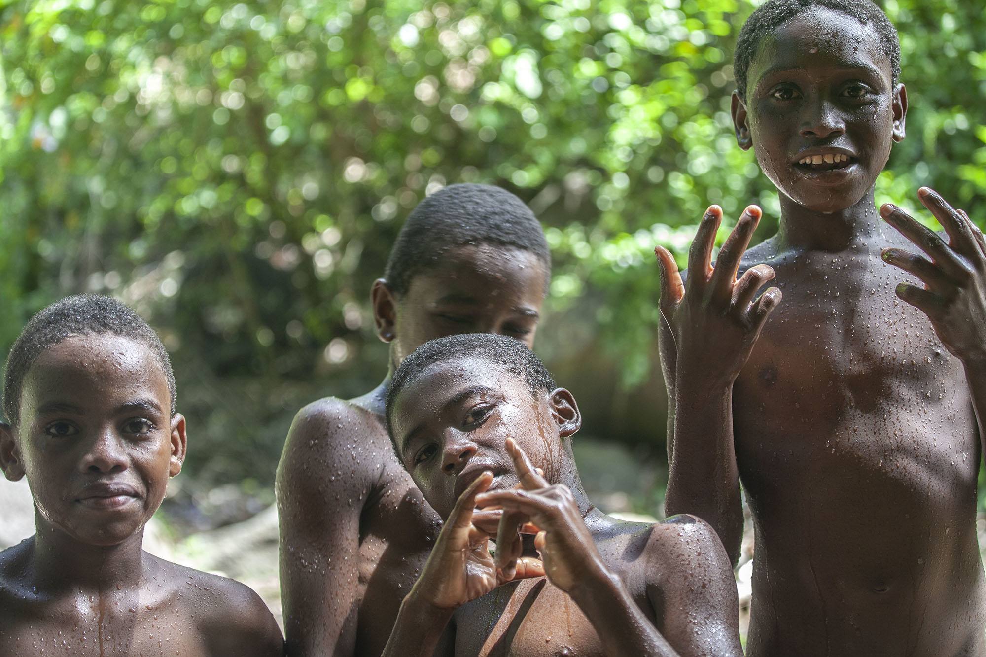 Comorian boys swimming at waterfall in Mutsamudu Anjouan Comoros