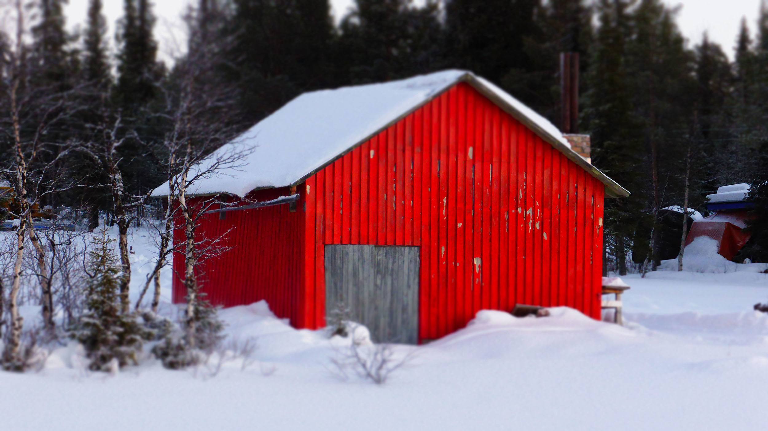 A red barn by a frozen lake near Camp Alta outside of Kiruna in Sweden