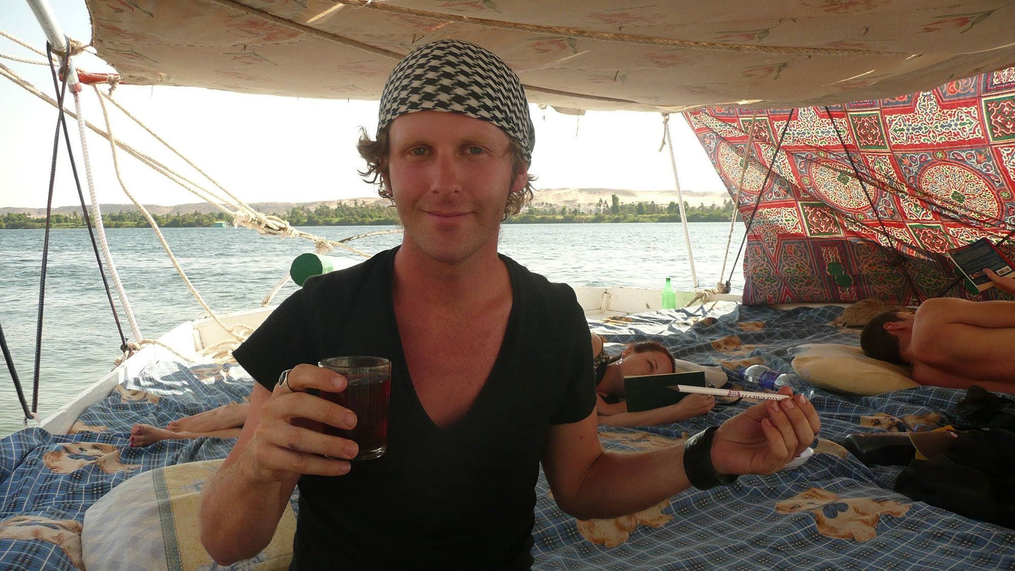 Ben on felucca sitting on bed having peppermint tea Nile Egypt