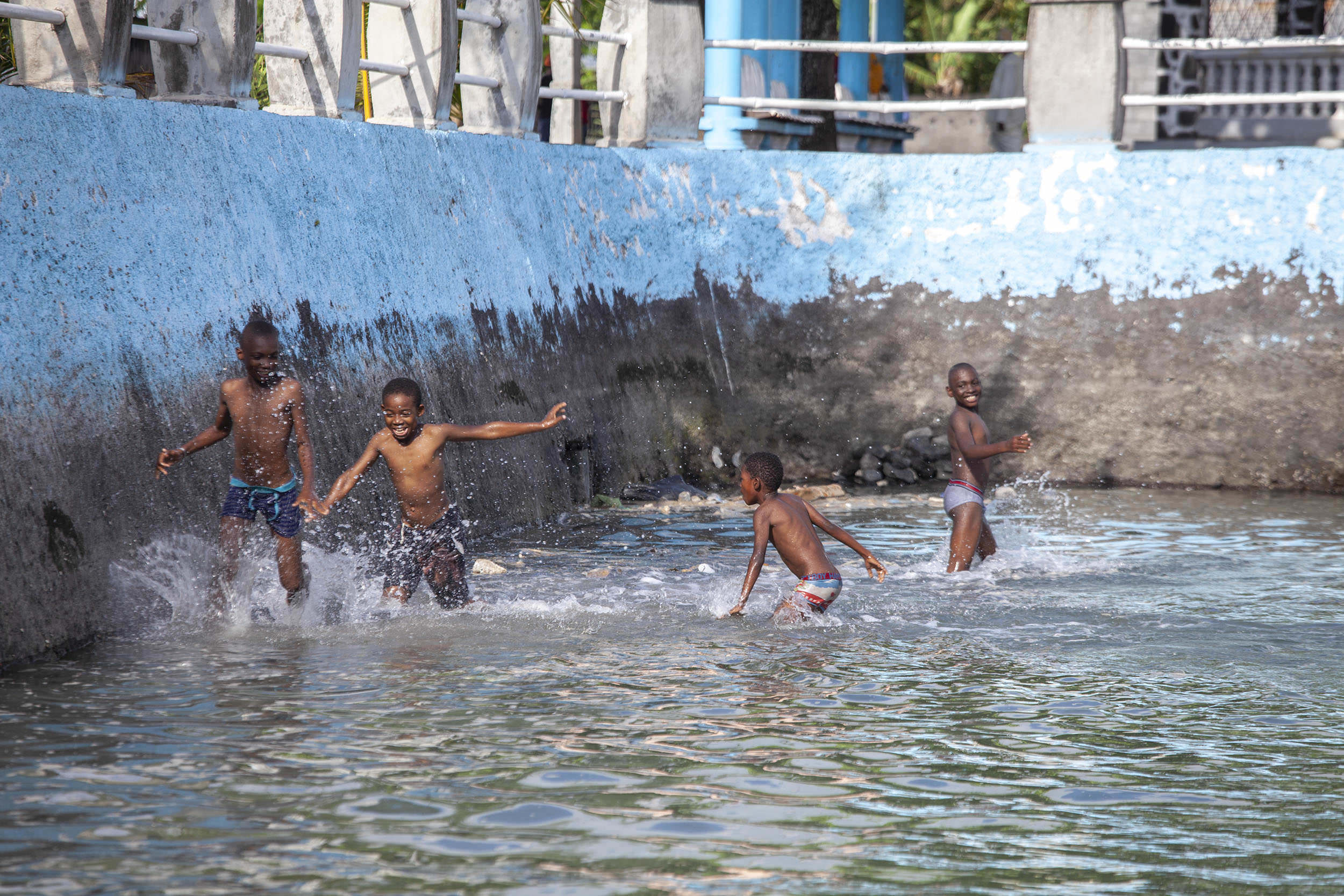 Children swimming in pond between mosque and palace ruins at Iconi Comoros