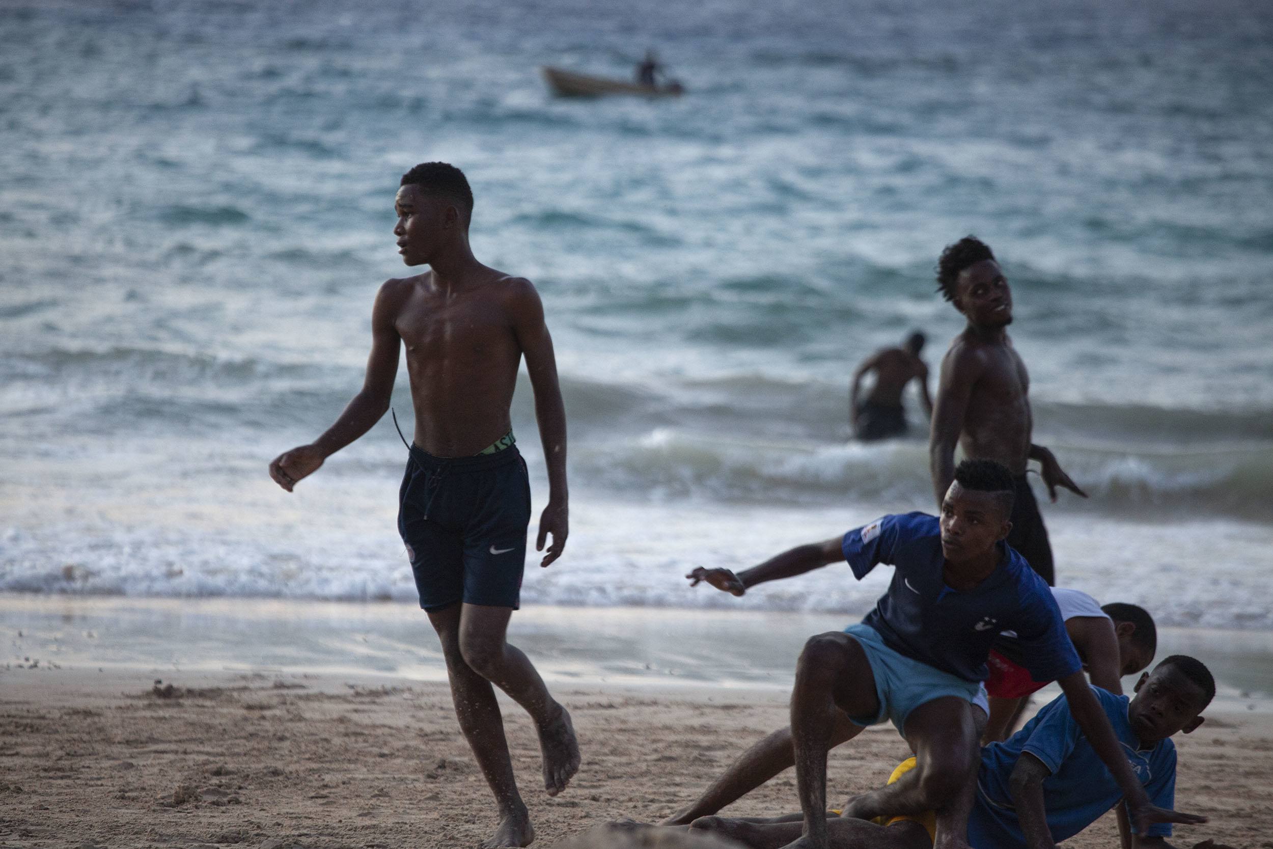 Comorian men tackling during game of football on Itsandra Beach Moroni Comoros