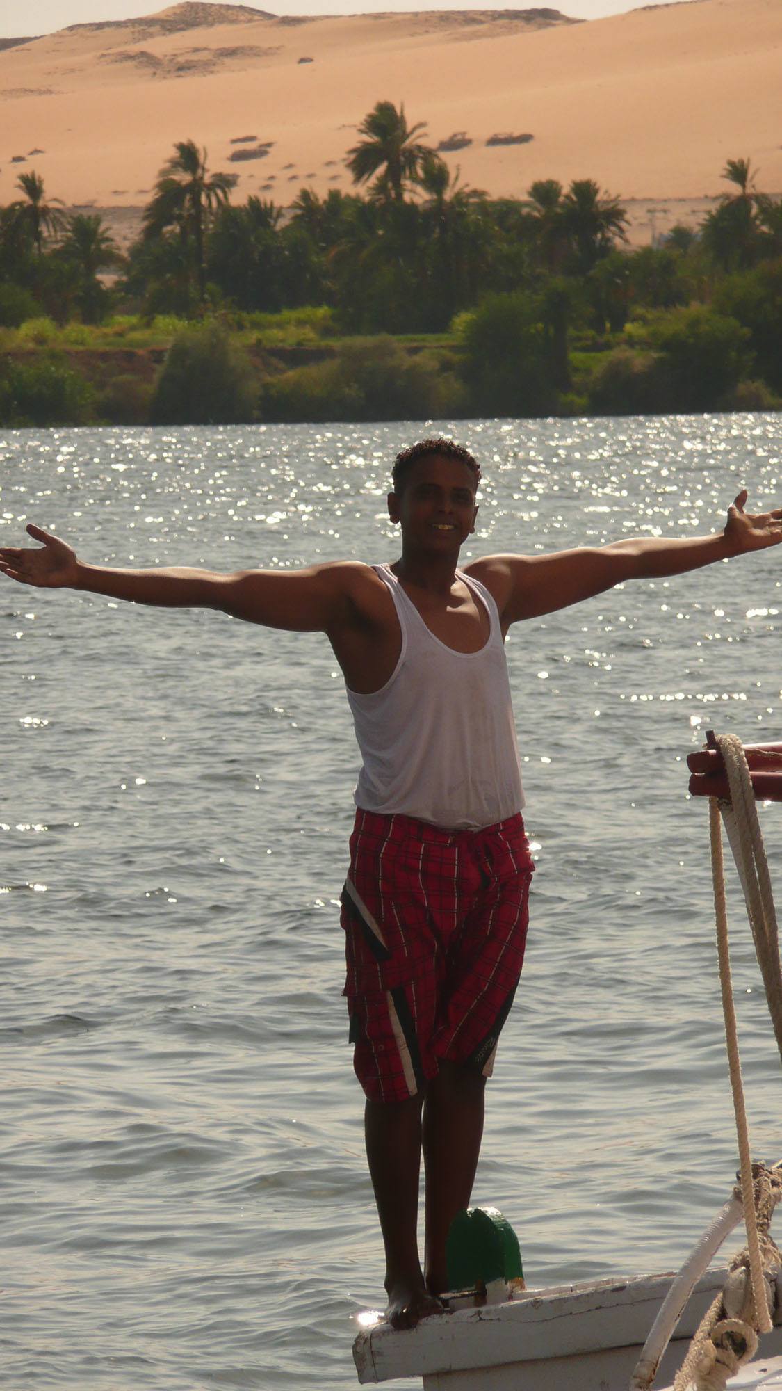 Egyptian man standing on the edge of felucca Egypt