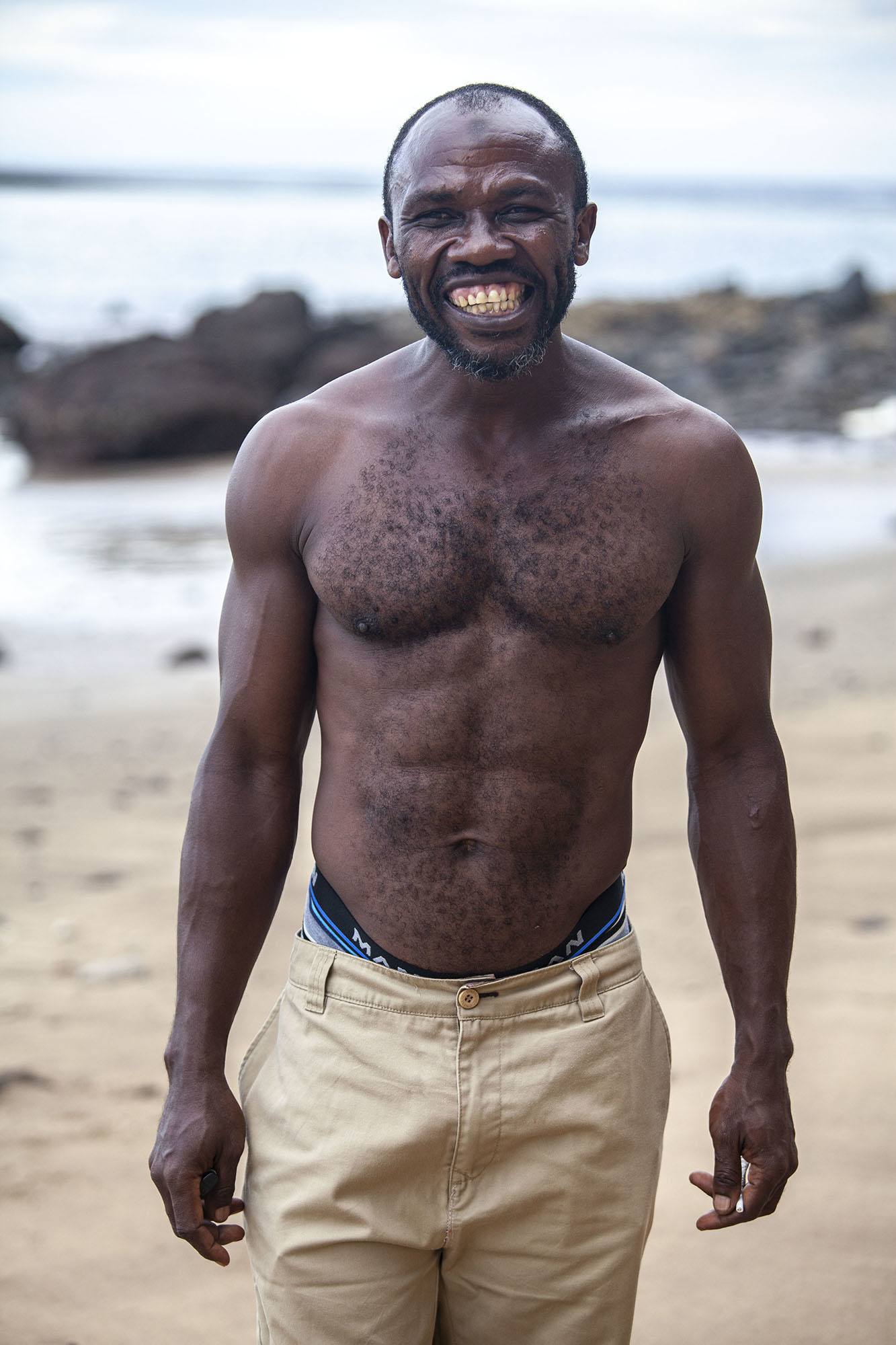 Shirtless smiling Comorian man on Itsamia beach Moheli Comoros