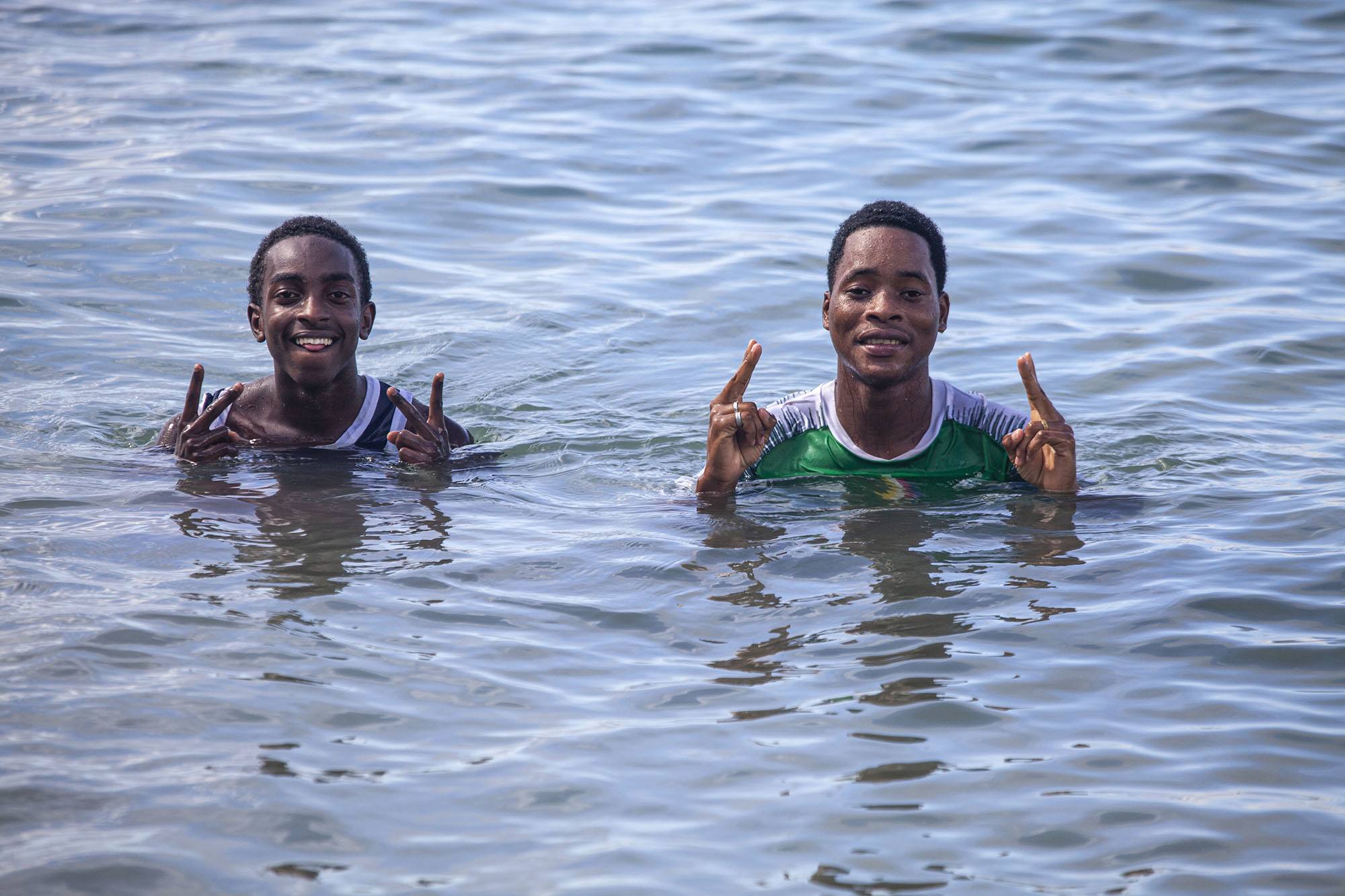 Two Comorian men swimming at Al Amal beach Mutsamudu Anjouan Comoros