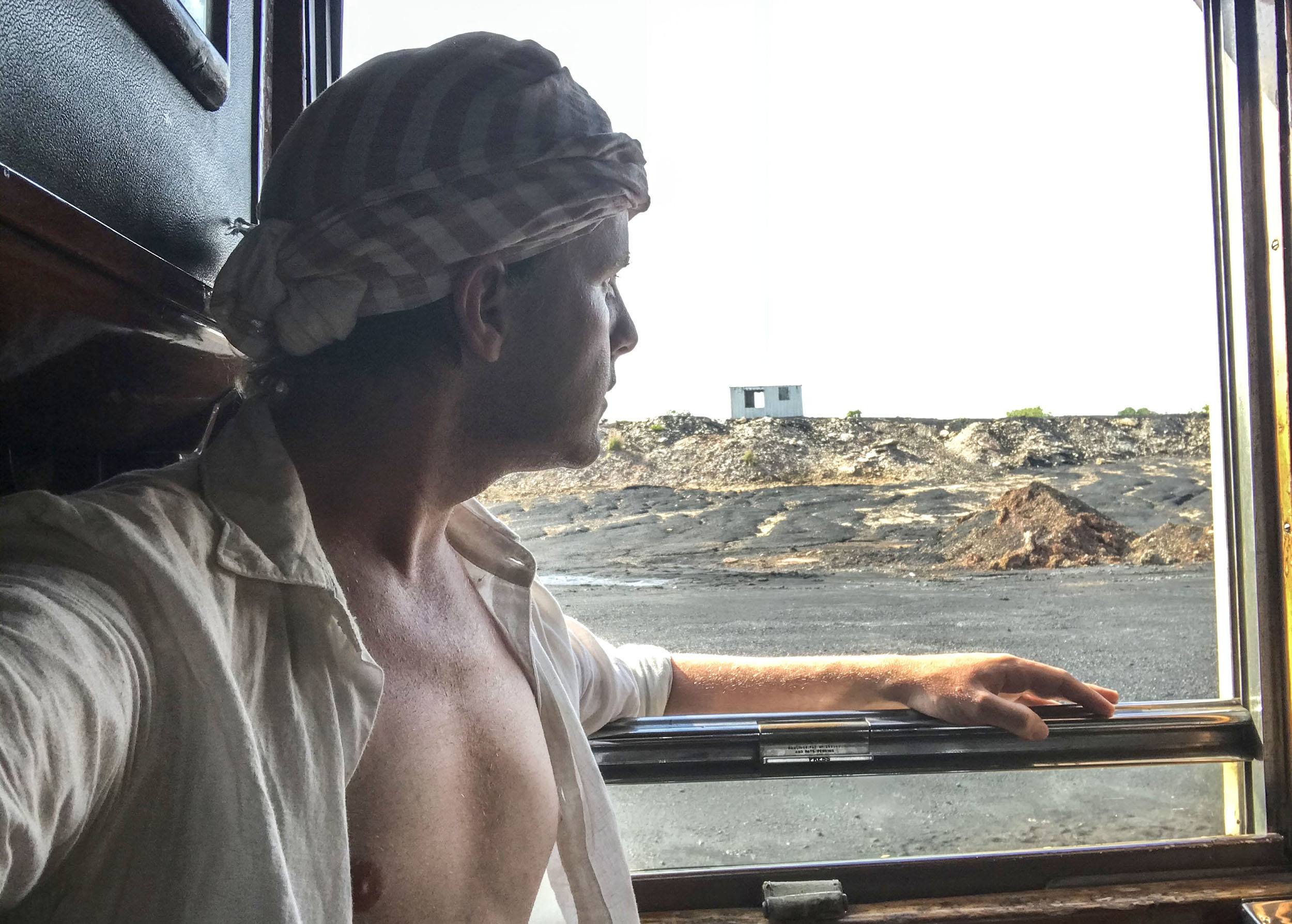 Ben looking out window of colonial train between Bulawayo and Victoria Falls Zimbabwe