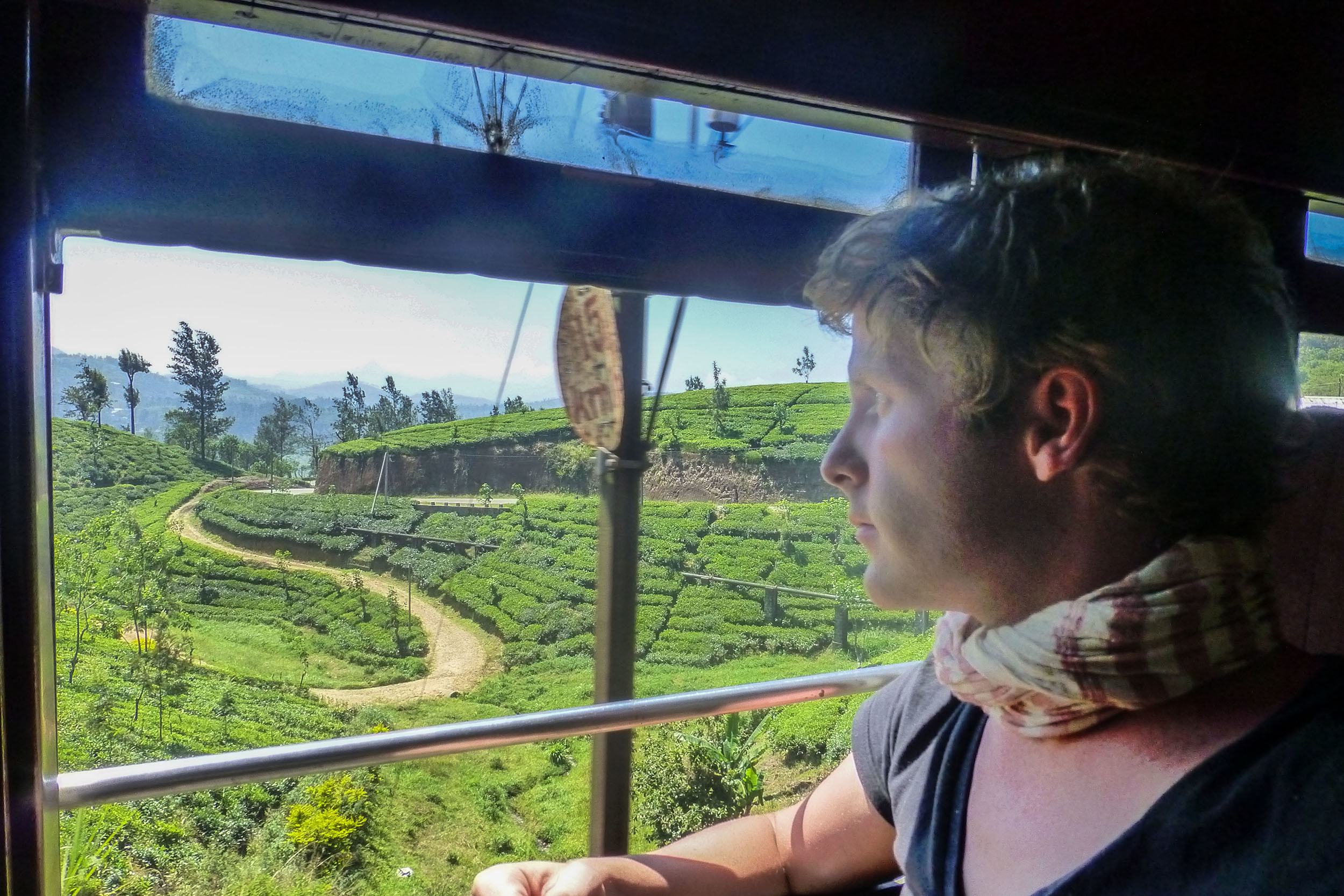 Ben looking out window of train between Kandy and Ella in Sri Lanka