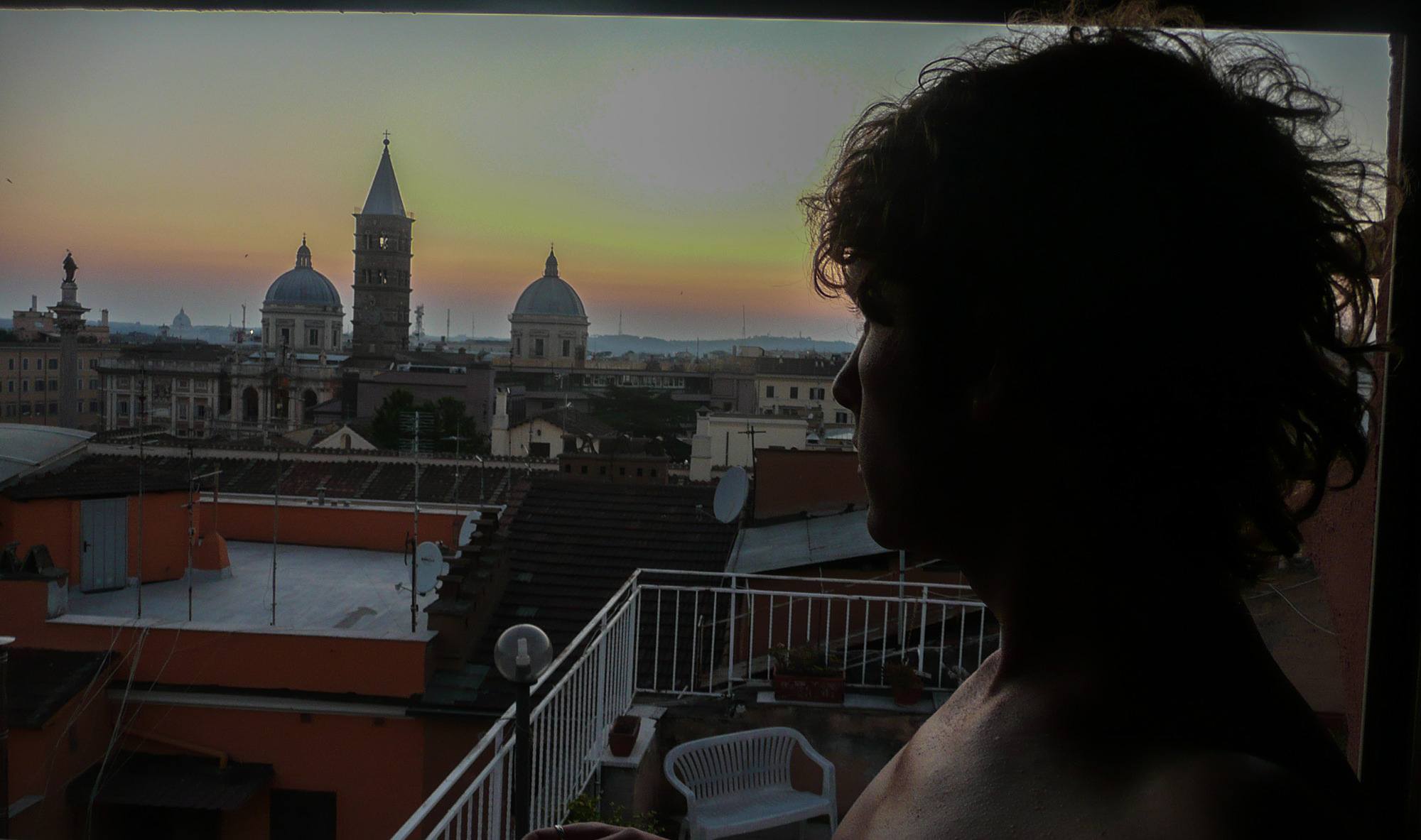 Ben looking over Rome at dusk from apartment window