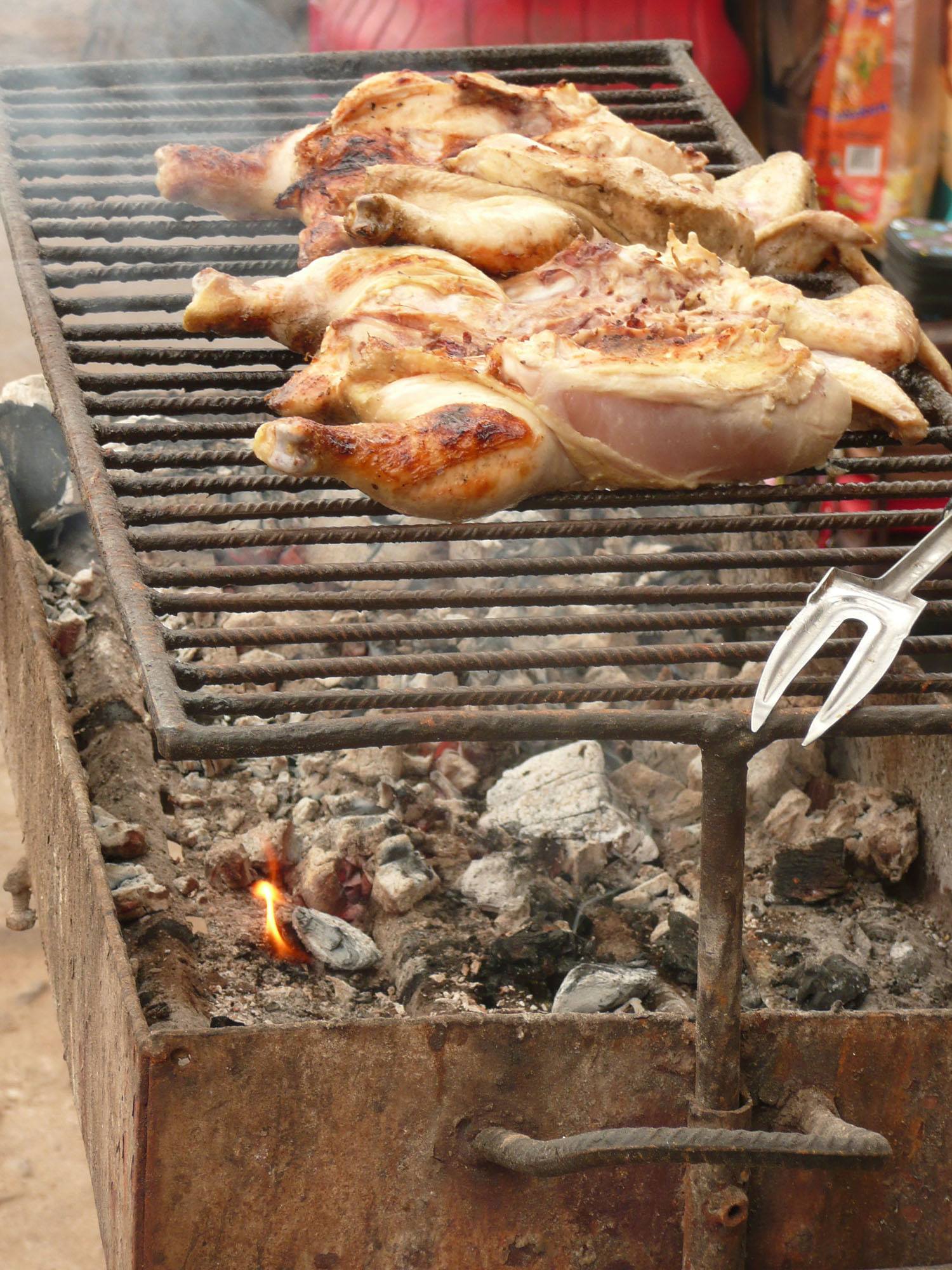 Grilling chicken on a barbeque in the streets of Maputo Mozambique