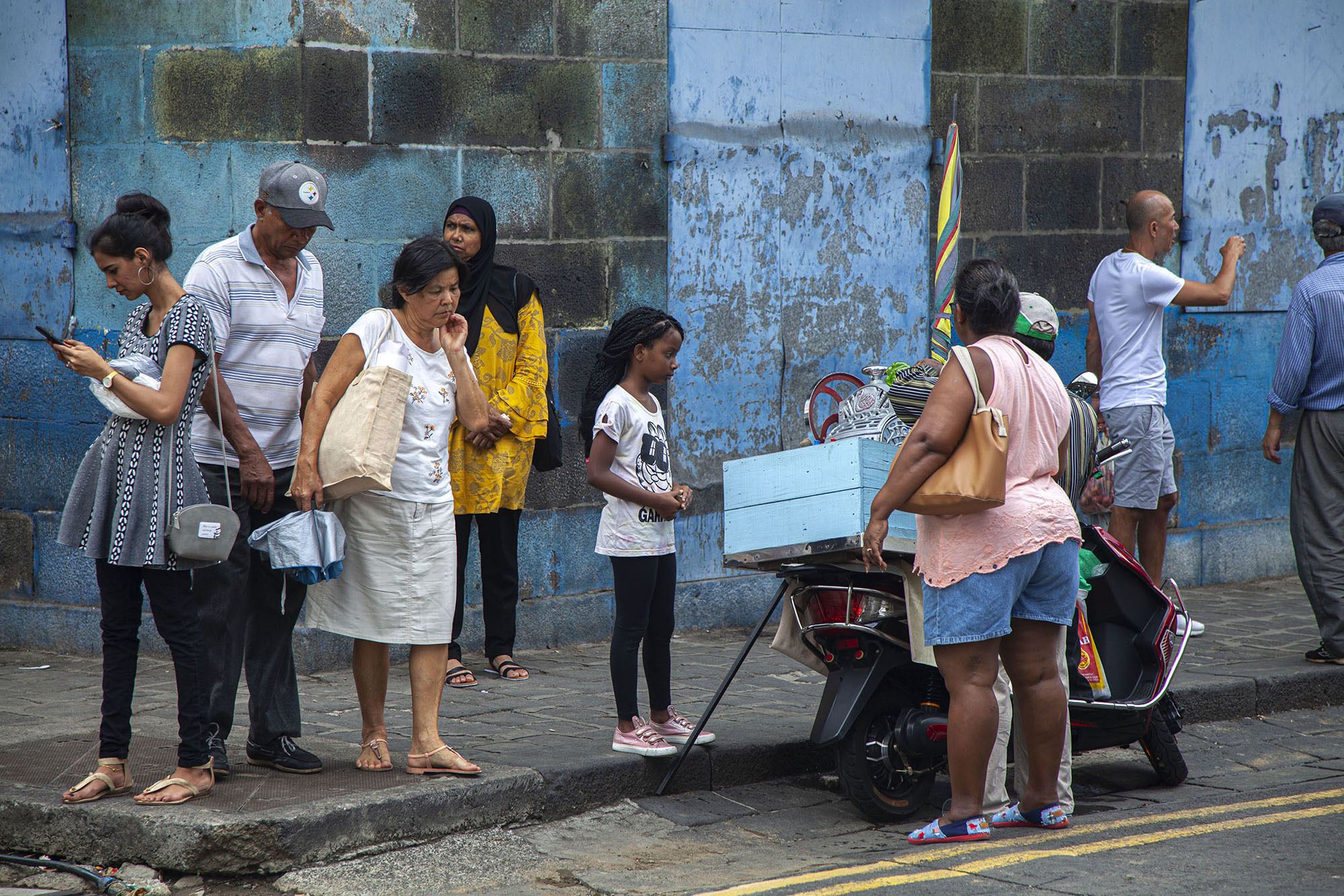 people on street corner buying drinks in Port Louis Mauritius