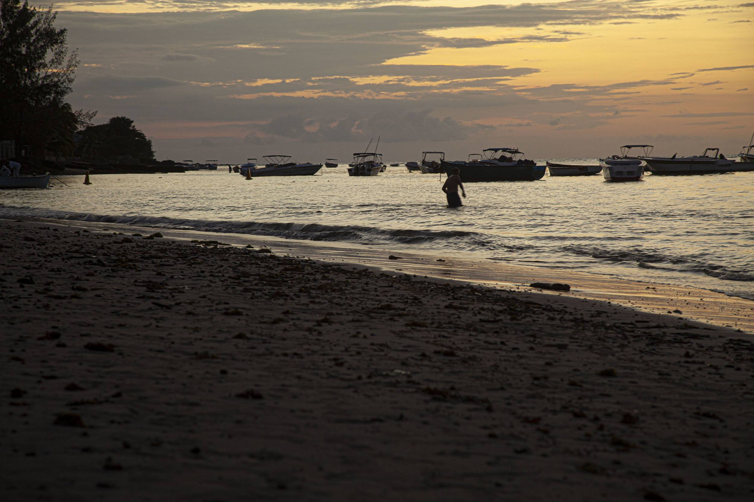 person swimming at Tamarin beach during dusk Mauritius