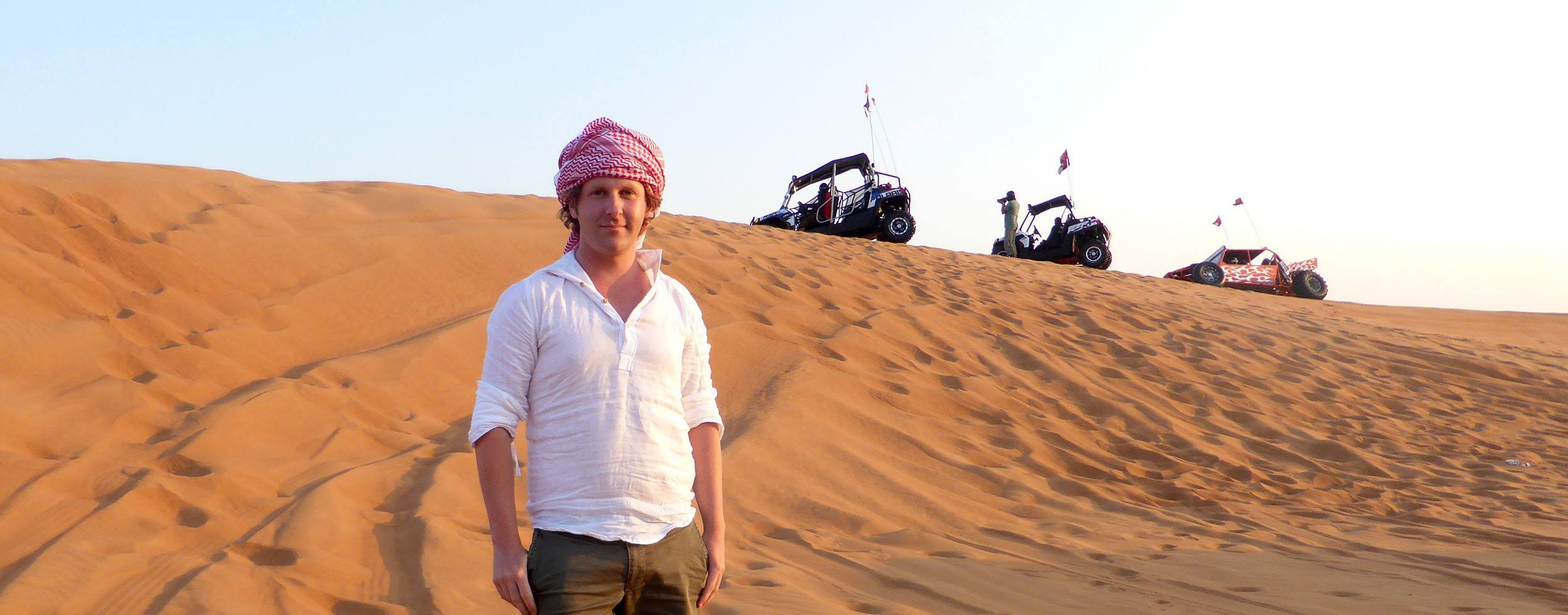 Ben in front of buggies in sand dunes near Dubai United Arab Emirates