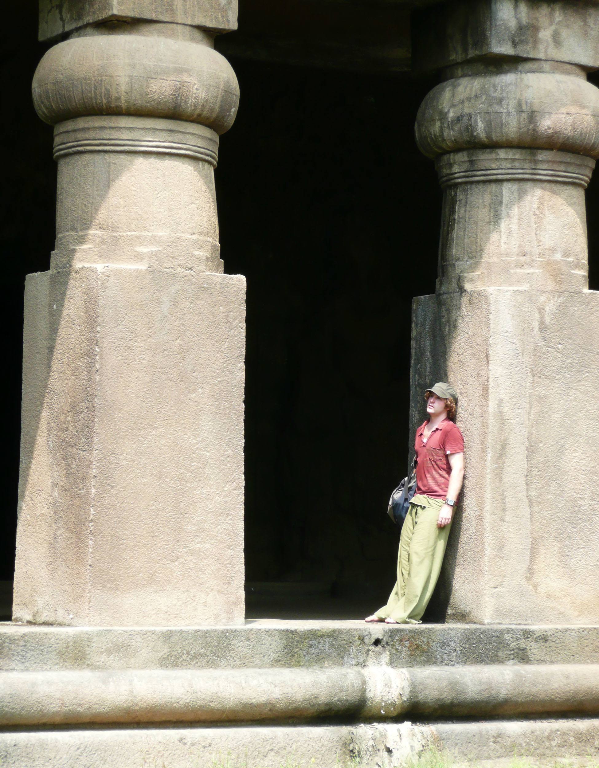 Ben leaning against column of building on Elephanta Island Mumbai India mid range