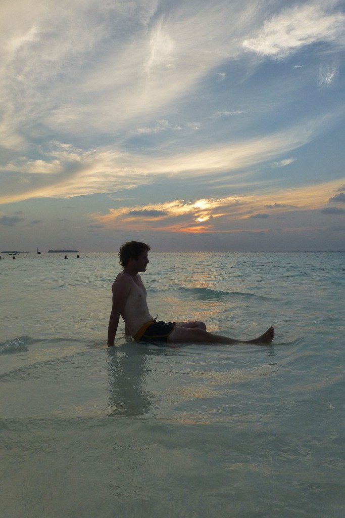 Ben sitting on sand bank near White Shell Beach on Maafushi the Maldives