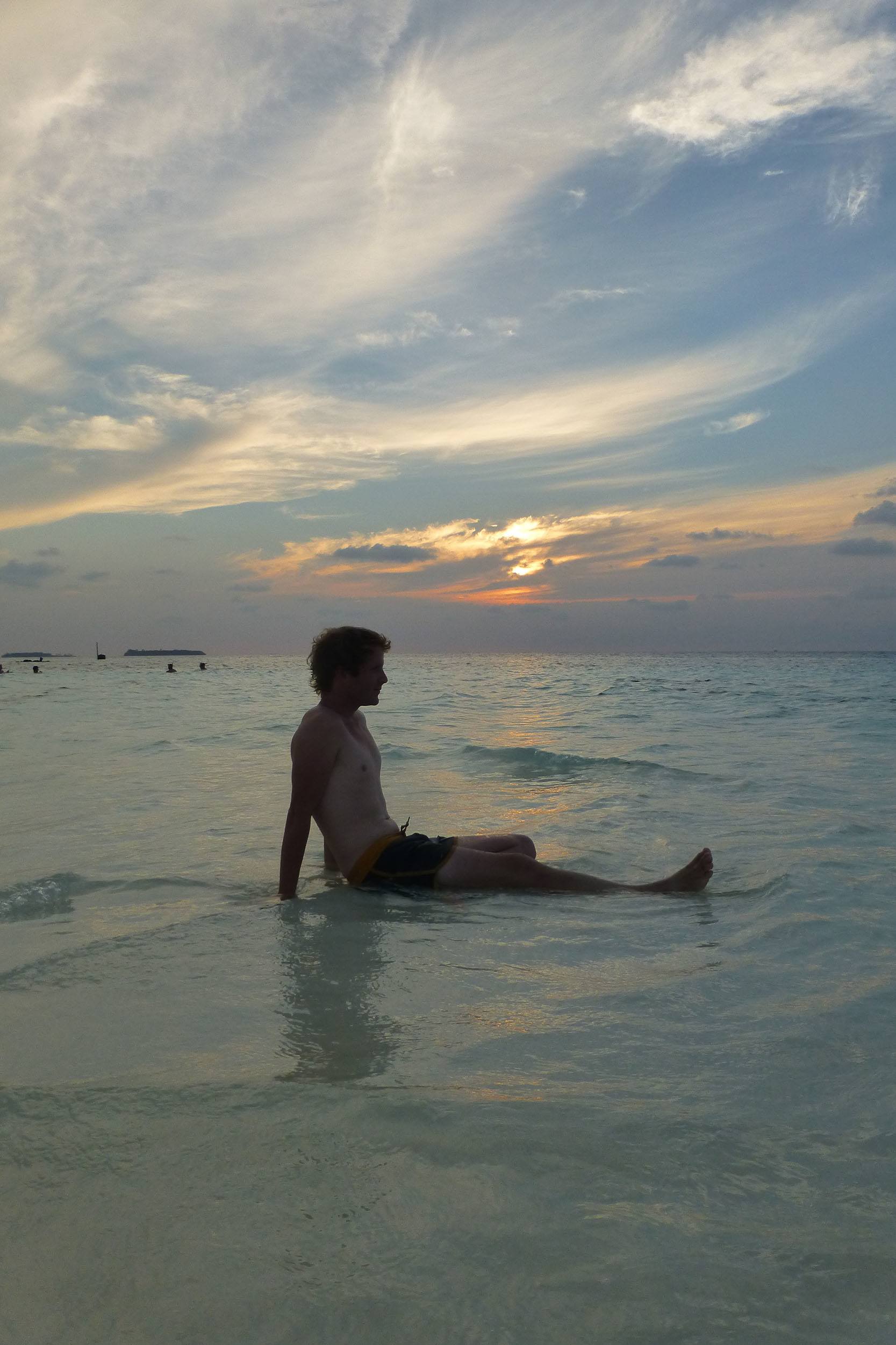 Ben sitting on sand bank near White Shell Beach on Maafushi the Maldives