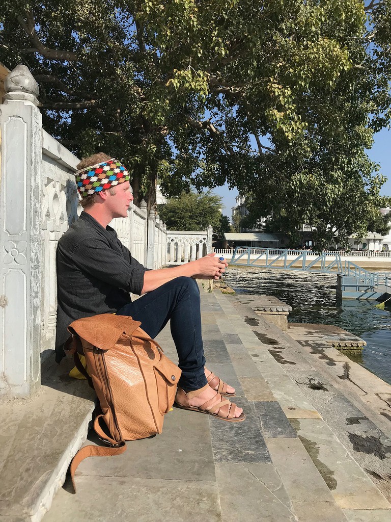 Ben sitting on steps beside Lake Pichola in Udaipur India