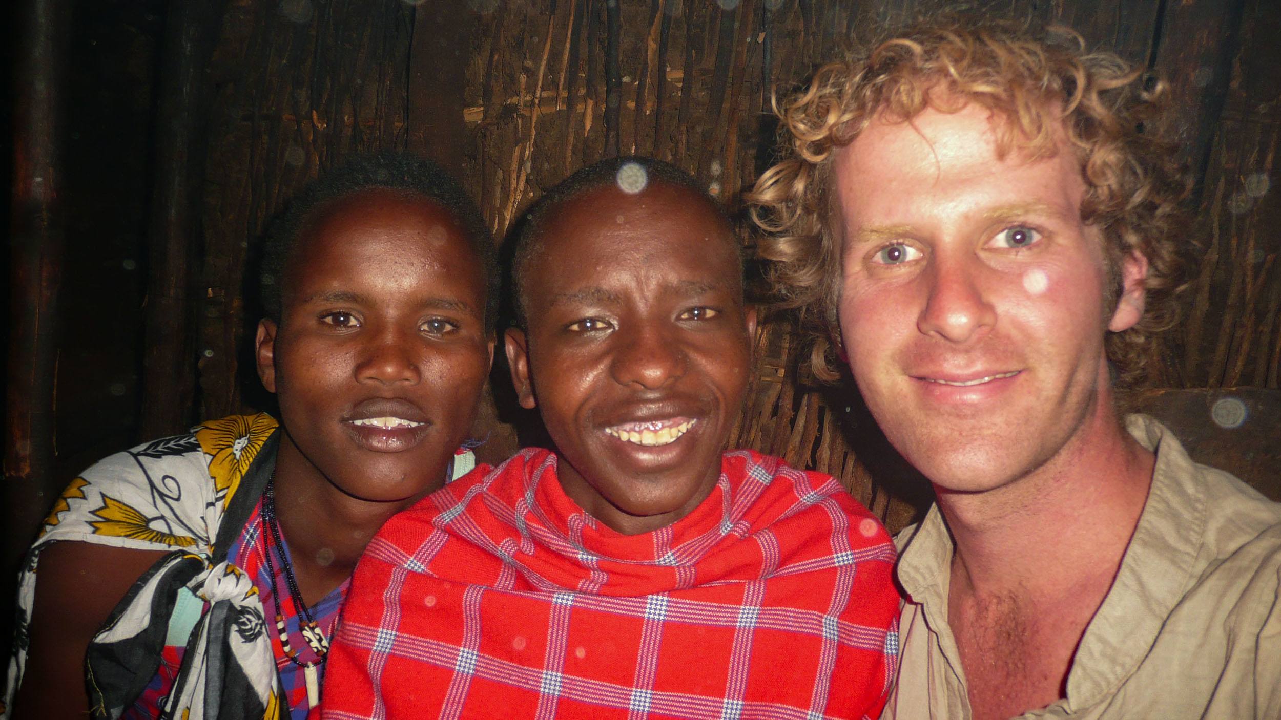 Ben sitting with a Maasai family inside their home in the Masai Mara Kenya
