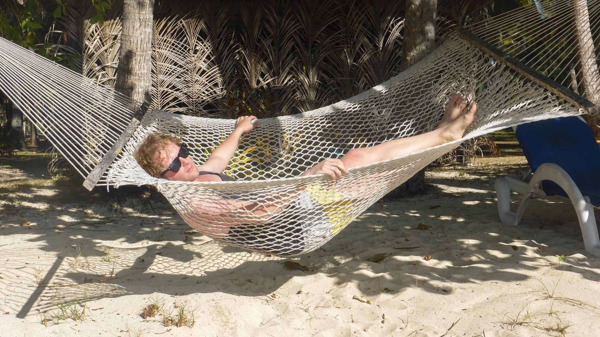 Ben swinging in a hammock on Blue Lagoon Resort Island beach Fiji