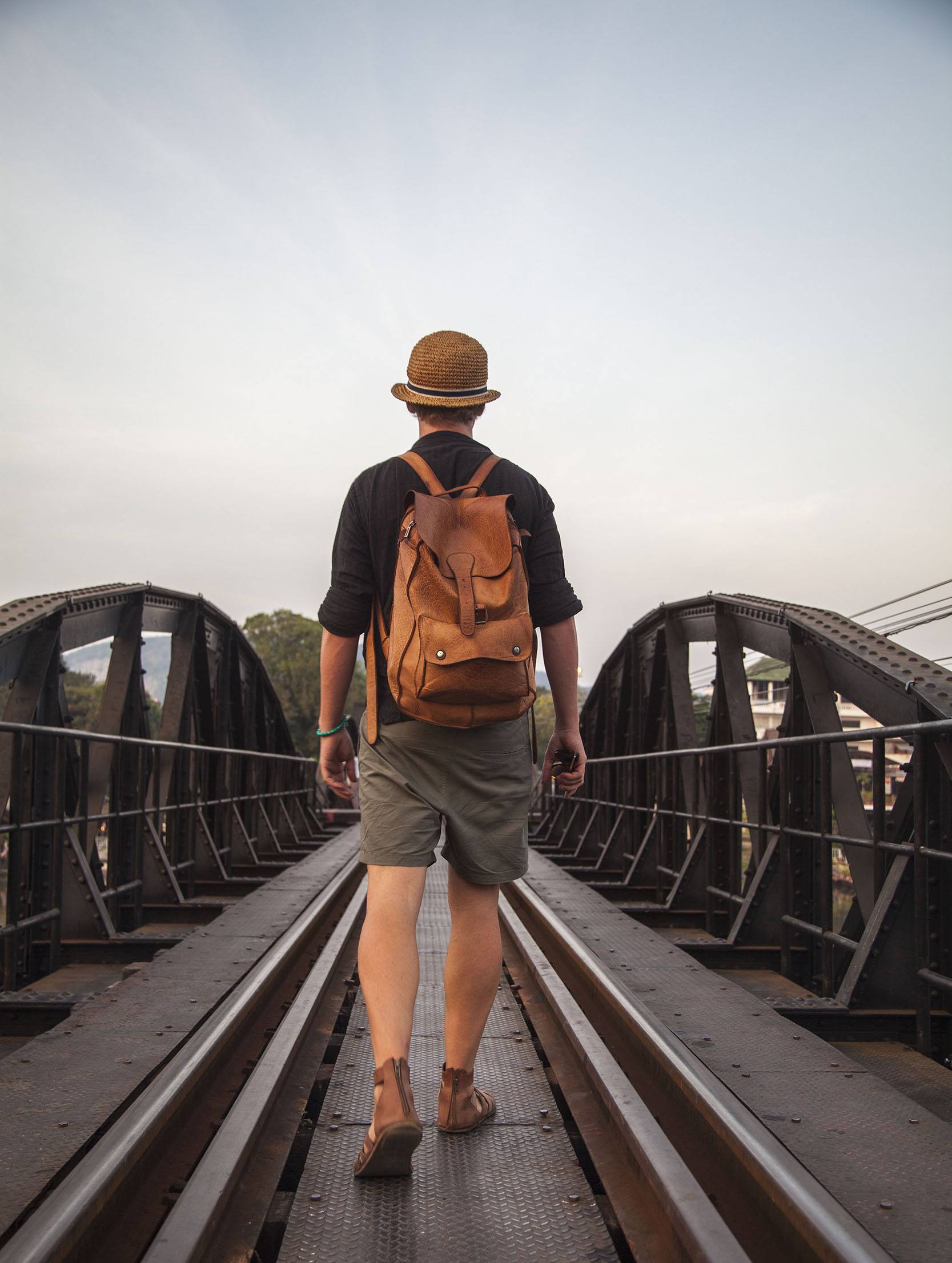 Ben walking along railway across bridge over River Kwai Kanchanaburi Thailand - Travel Solo At Least Once It Can Be Rewarding
