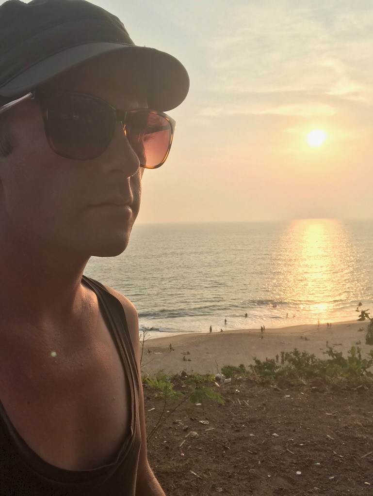 Ben wearing sunglasses at dusk on a beach in Kerala India