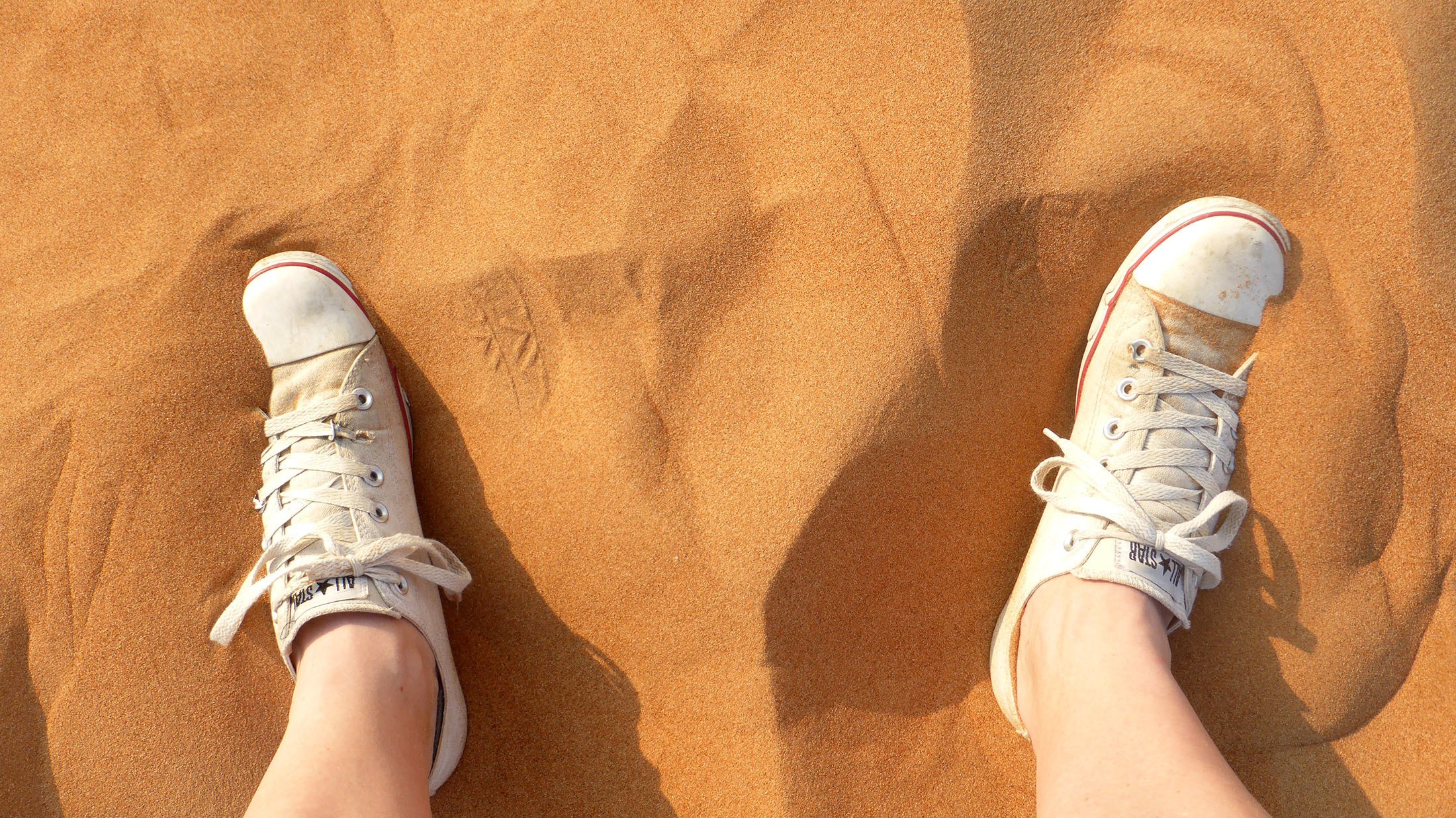 Ben's converse and feet in the sand near Dubai United Arab Emirates