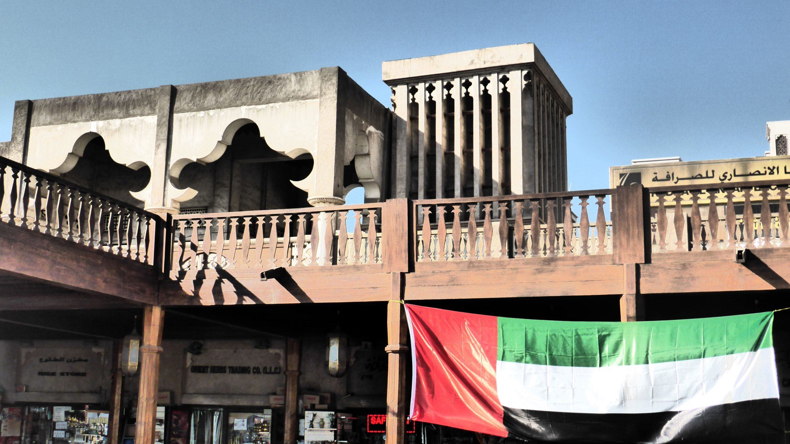 Building near Dubai Museum hanging the United Arab Emirates flag from a balcony