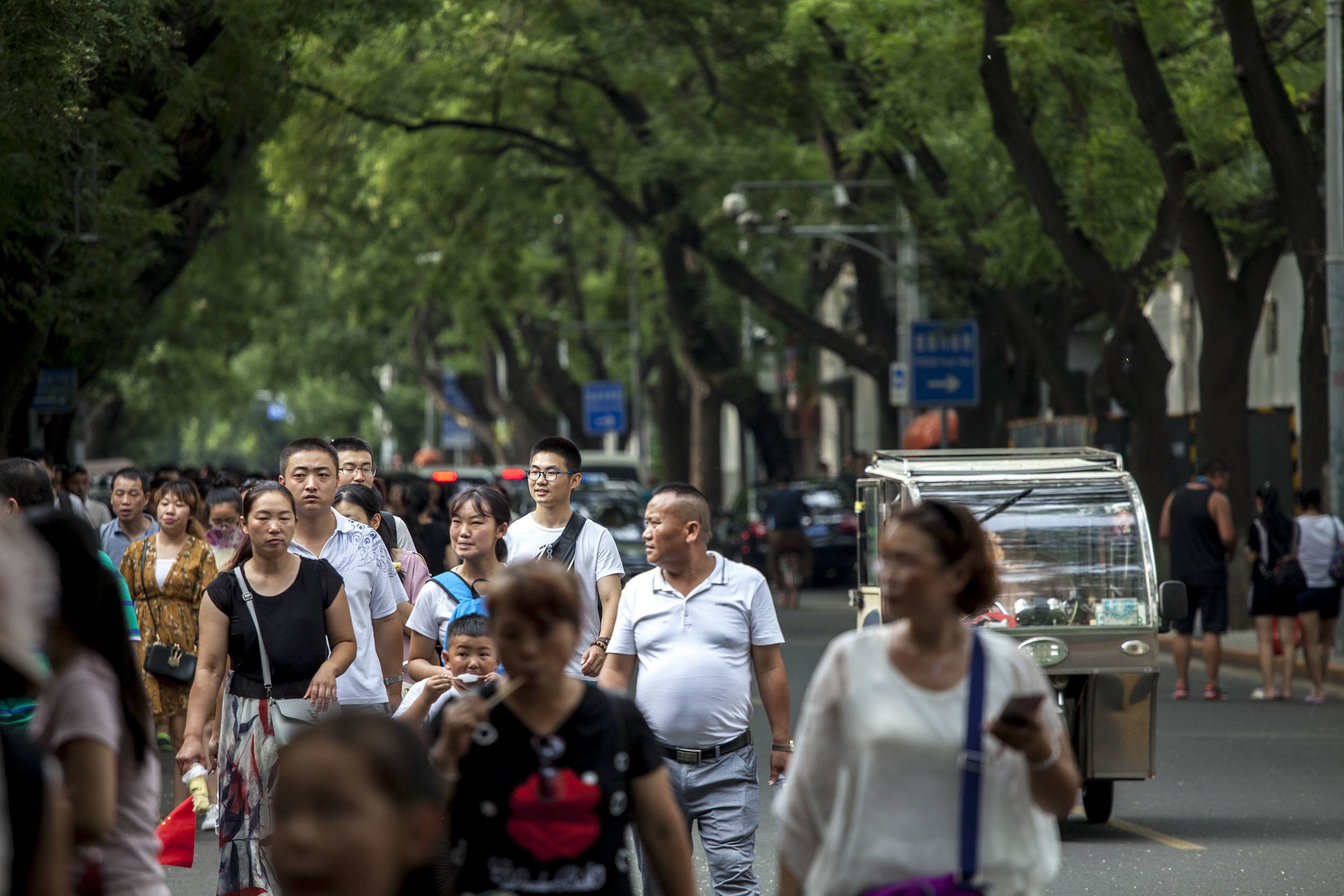 Chinese people walking through the streets of Beijing China
