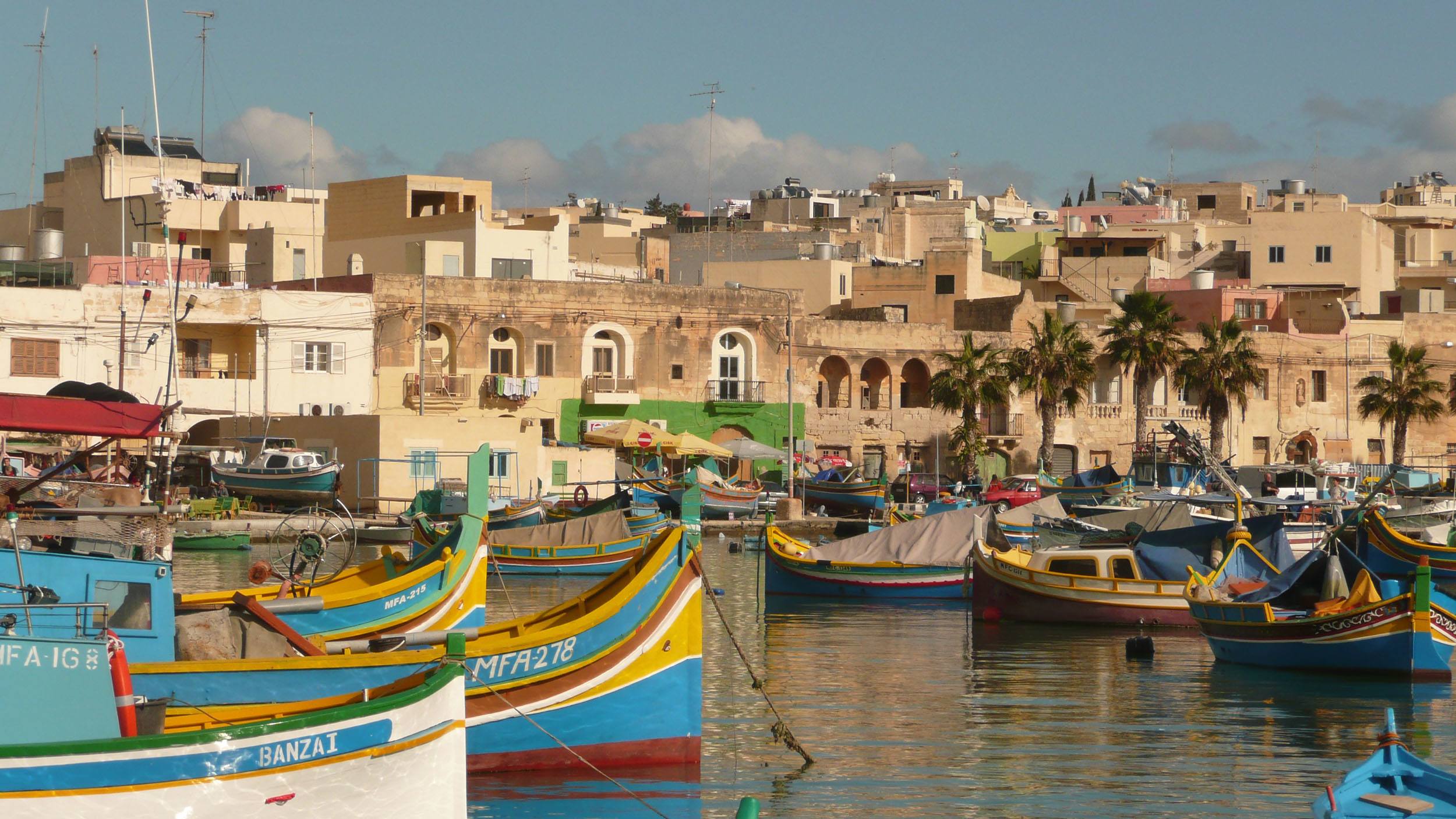 Colourful boats docked in water in Marsaxlokk Malta