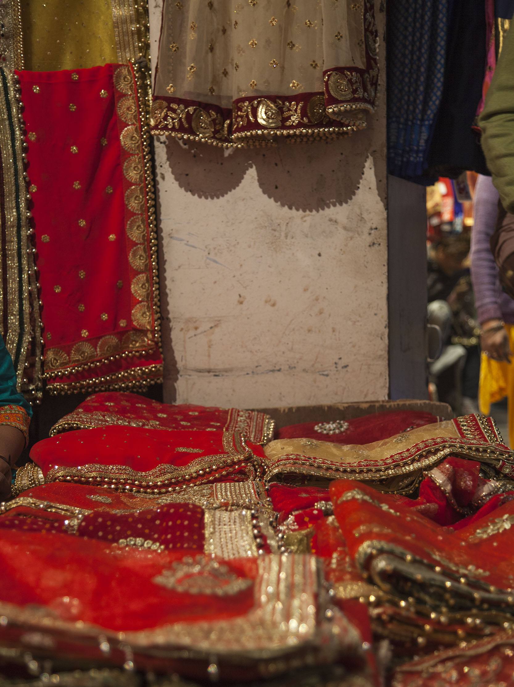 Colourful fabric outside shop in small alley of city in India