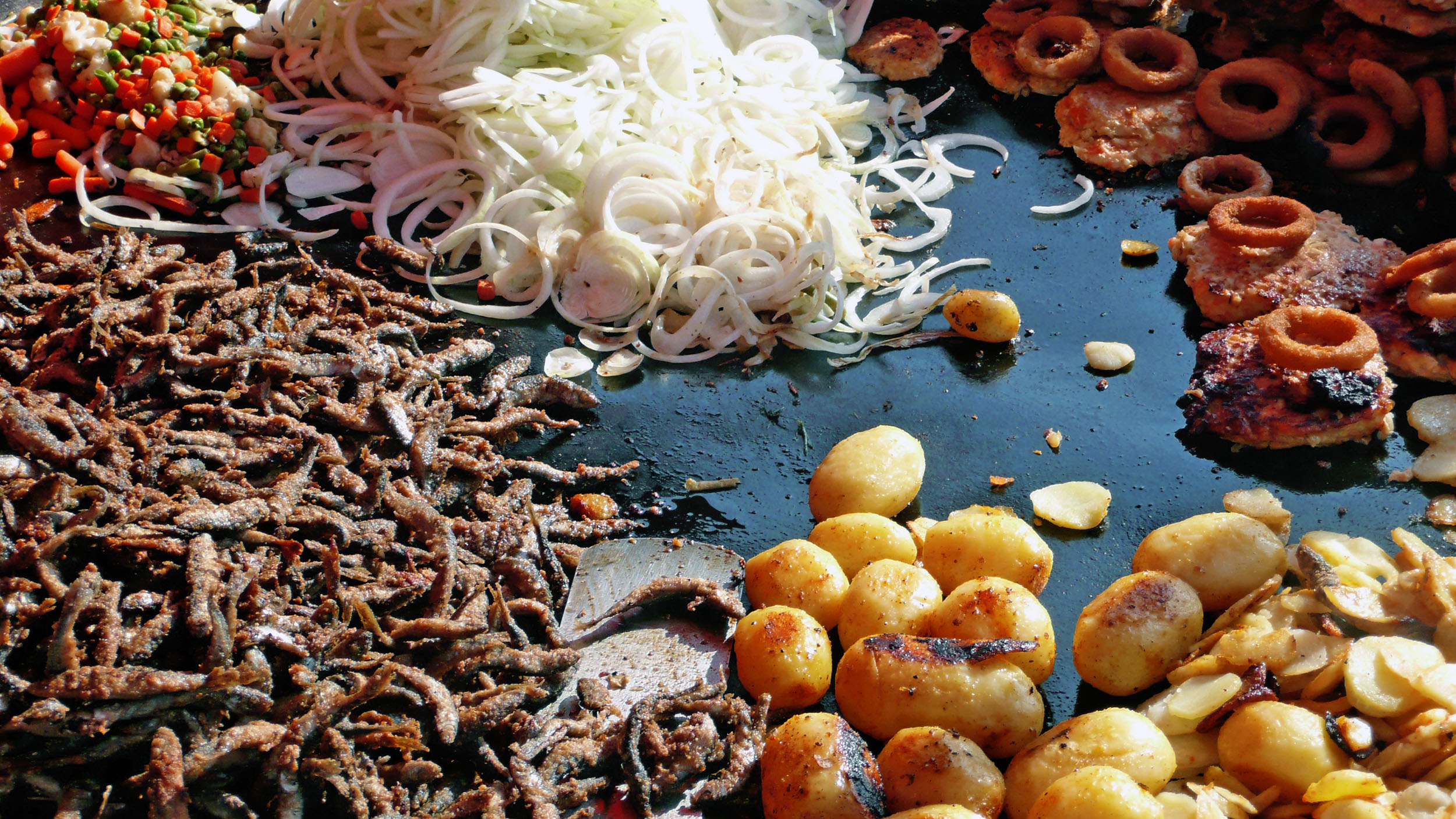 Fish and vegetables frying on hot plate in Market Square Helsinki Finland