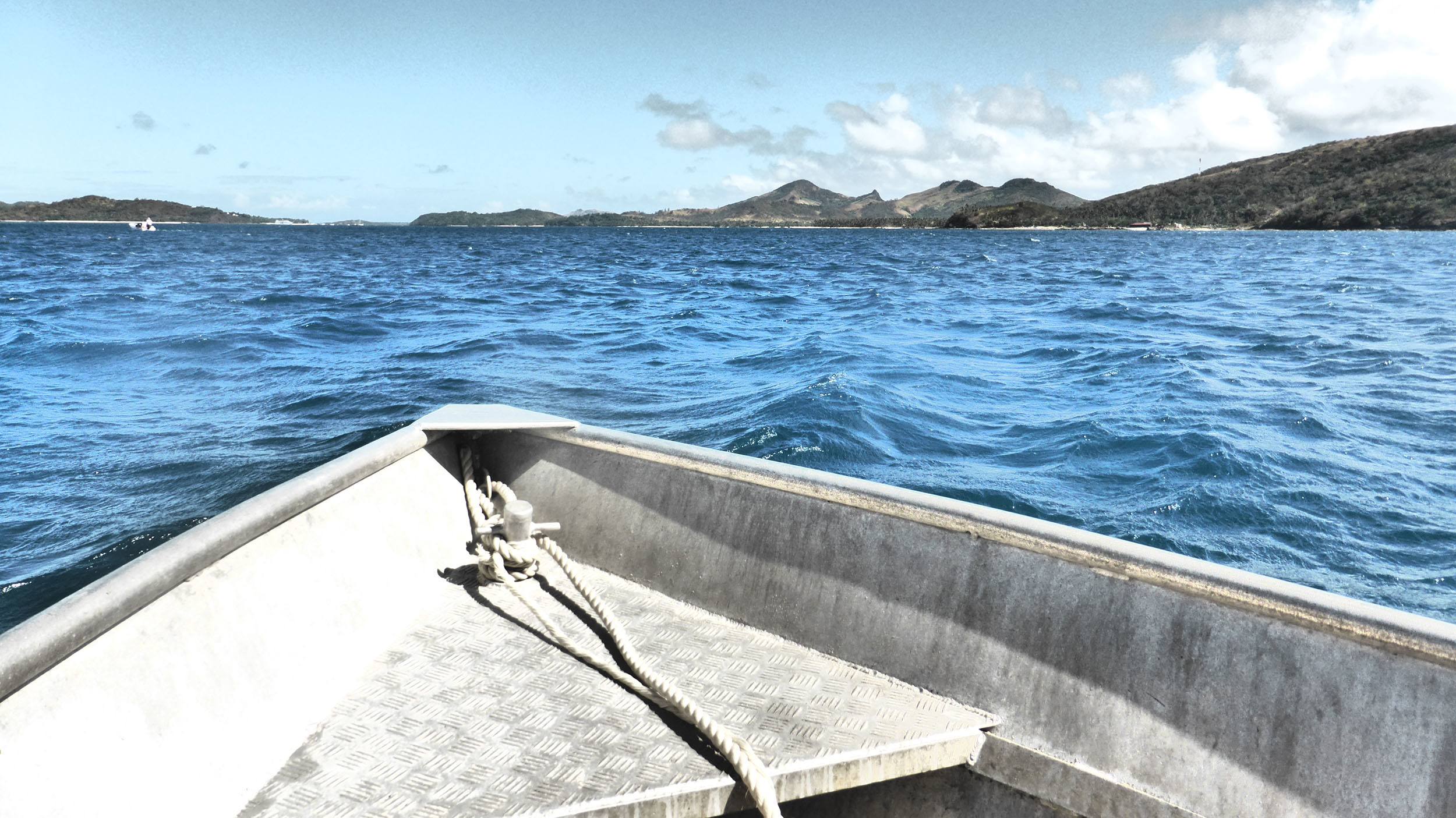 Front of speedboat caught while moving through the ocean between islands in Fiji