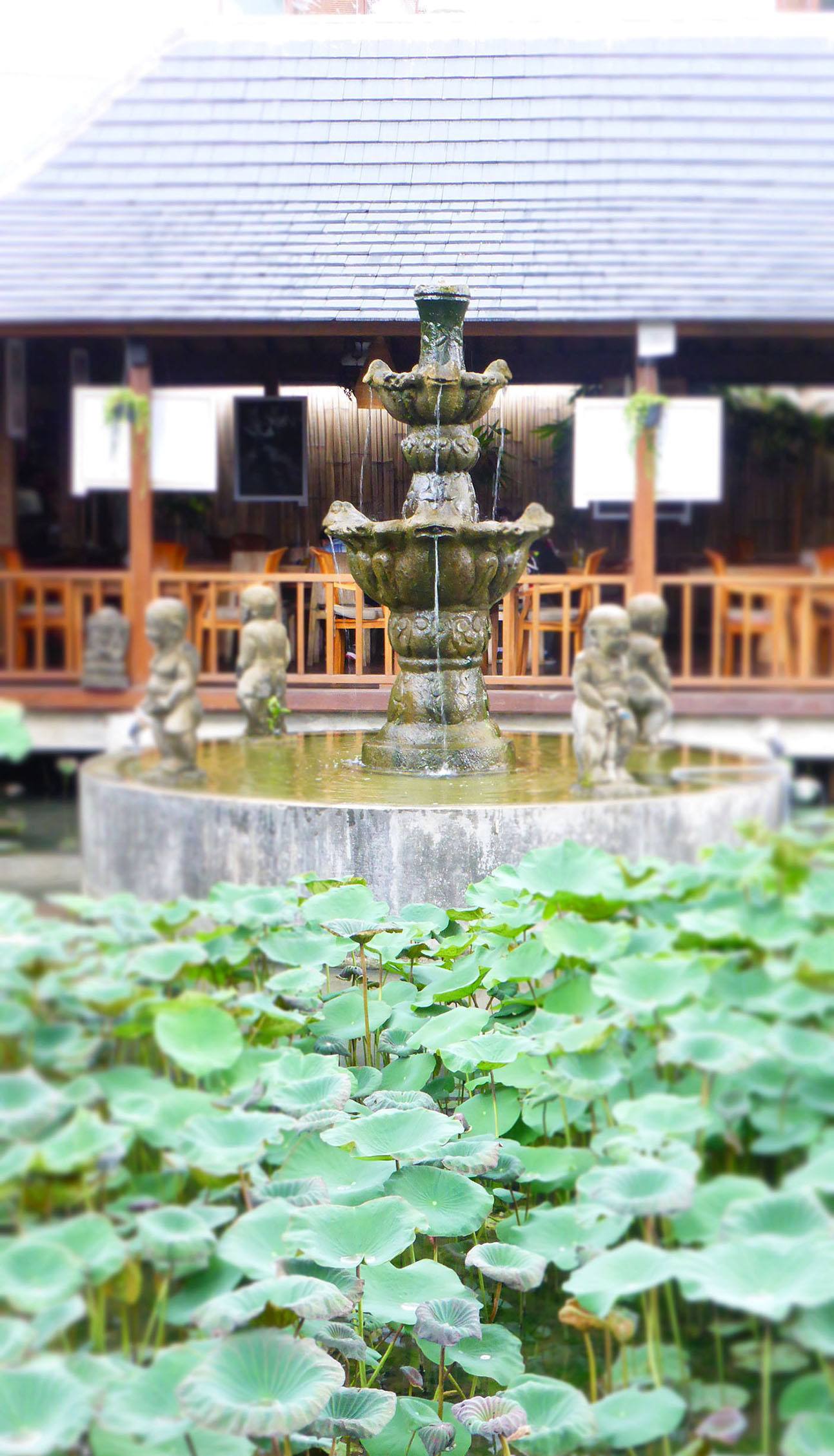 Gardens and fountain of restaurant and shops along Jalan Moneky Forest in Ubud Bali Indonesia