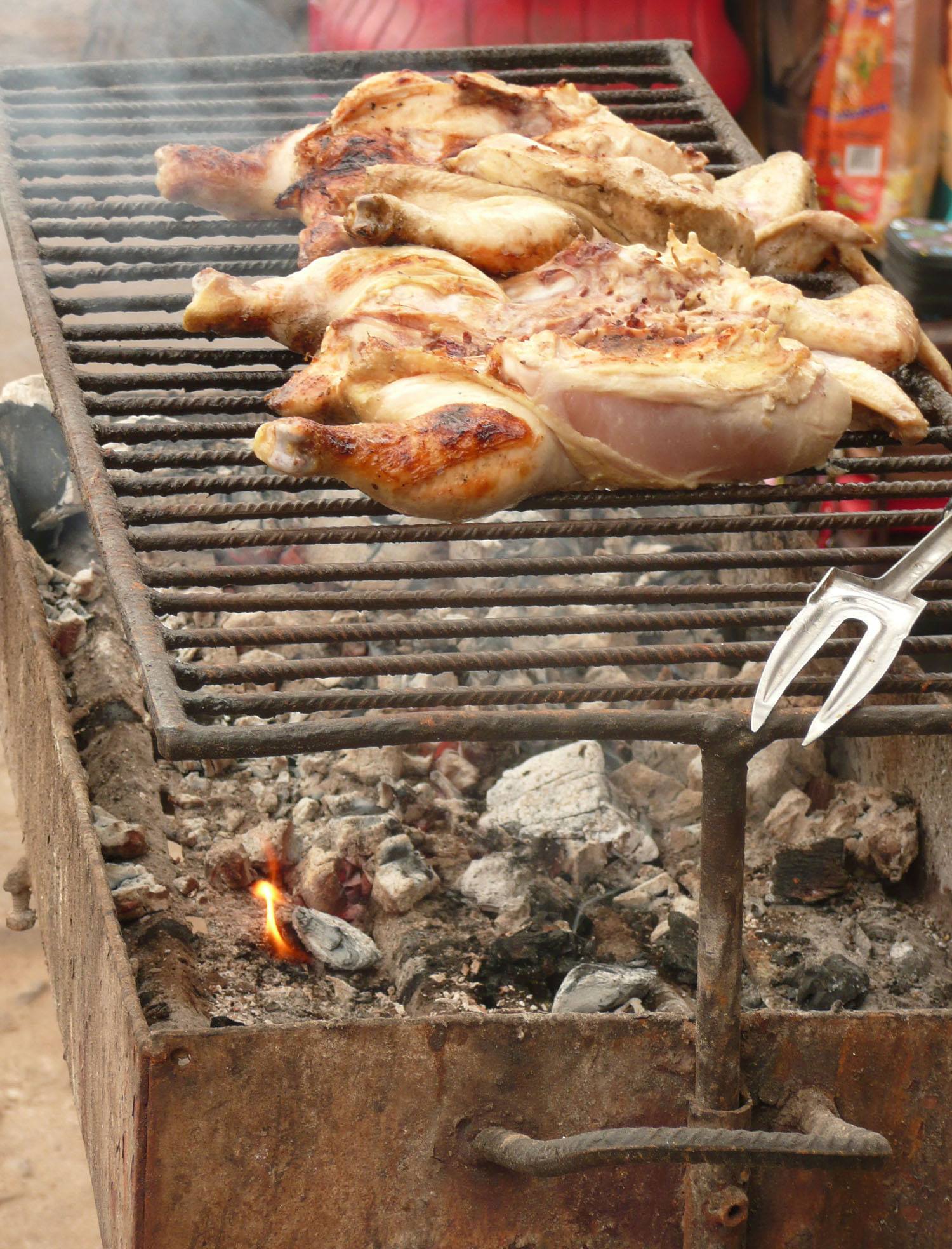 Grilling chicken on a barbeque in the streets of Maputo Mozambique