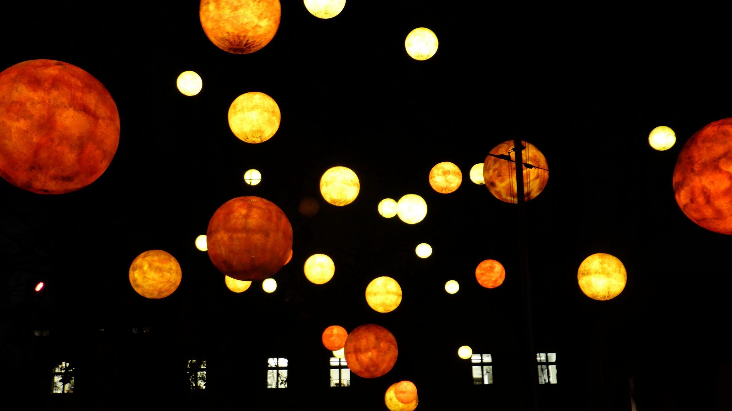 Hanging lanterns glowing at night in square near Pfefferbett Hostel Berlin Germany