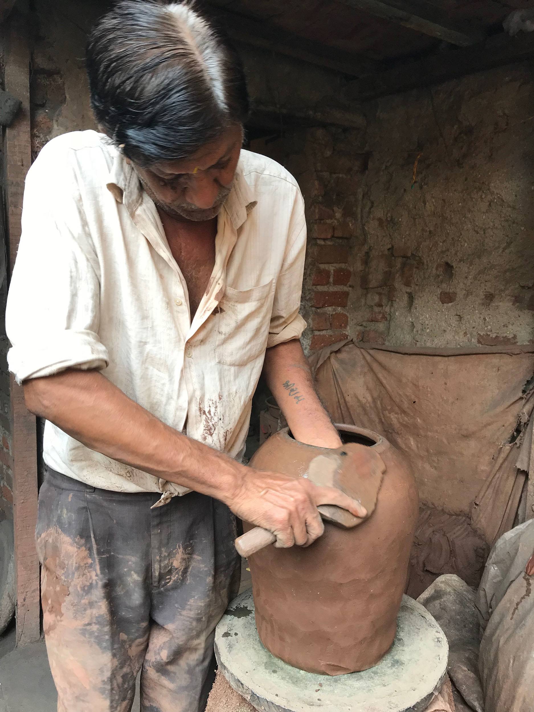 Indian potter throwing clay pot inside Dharavi slum Mumbai India