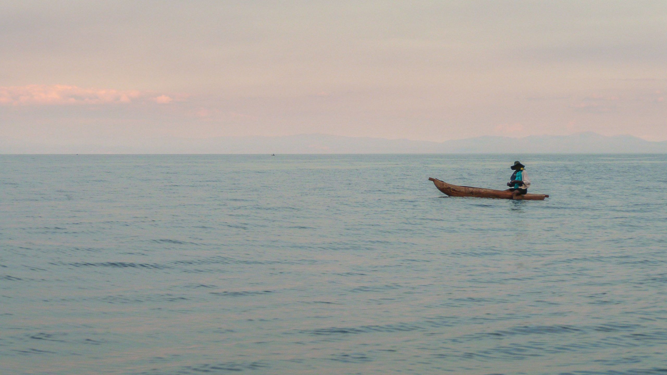 Man with hat in boat on Lake Malawi near Nkhata Bay Malawi