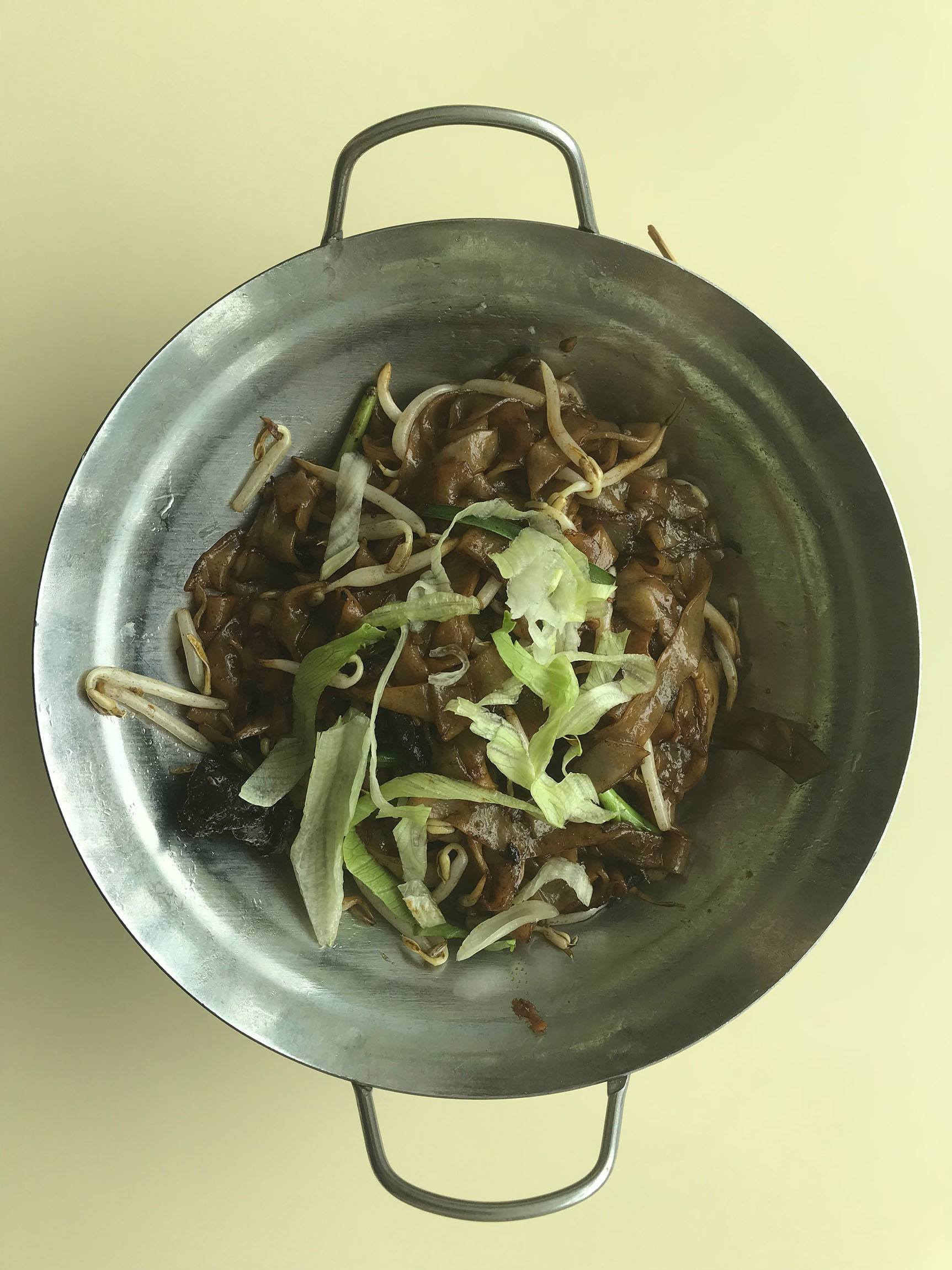 Metal bowl of fried meat and noodles