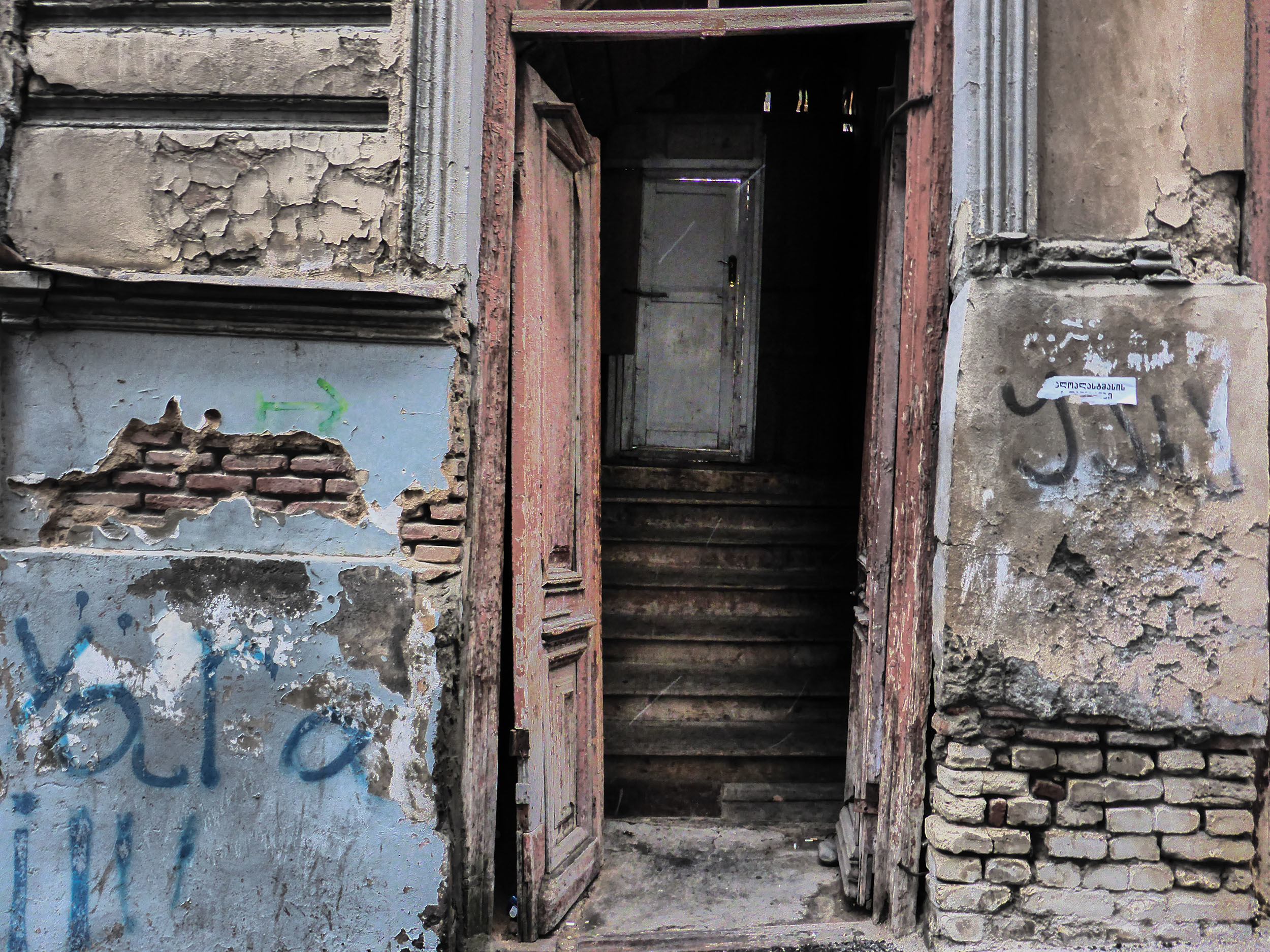 Open doorway to crumbling house in Old Town Tbilisi Georgia