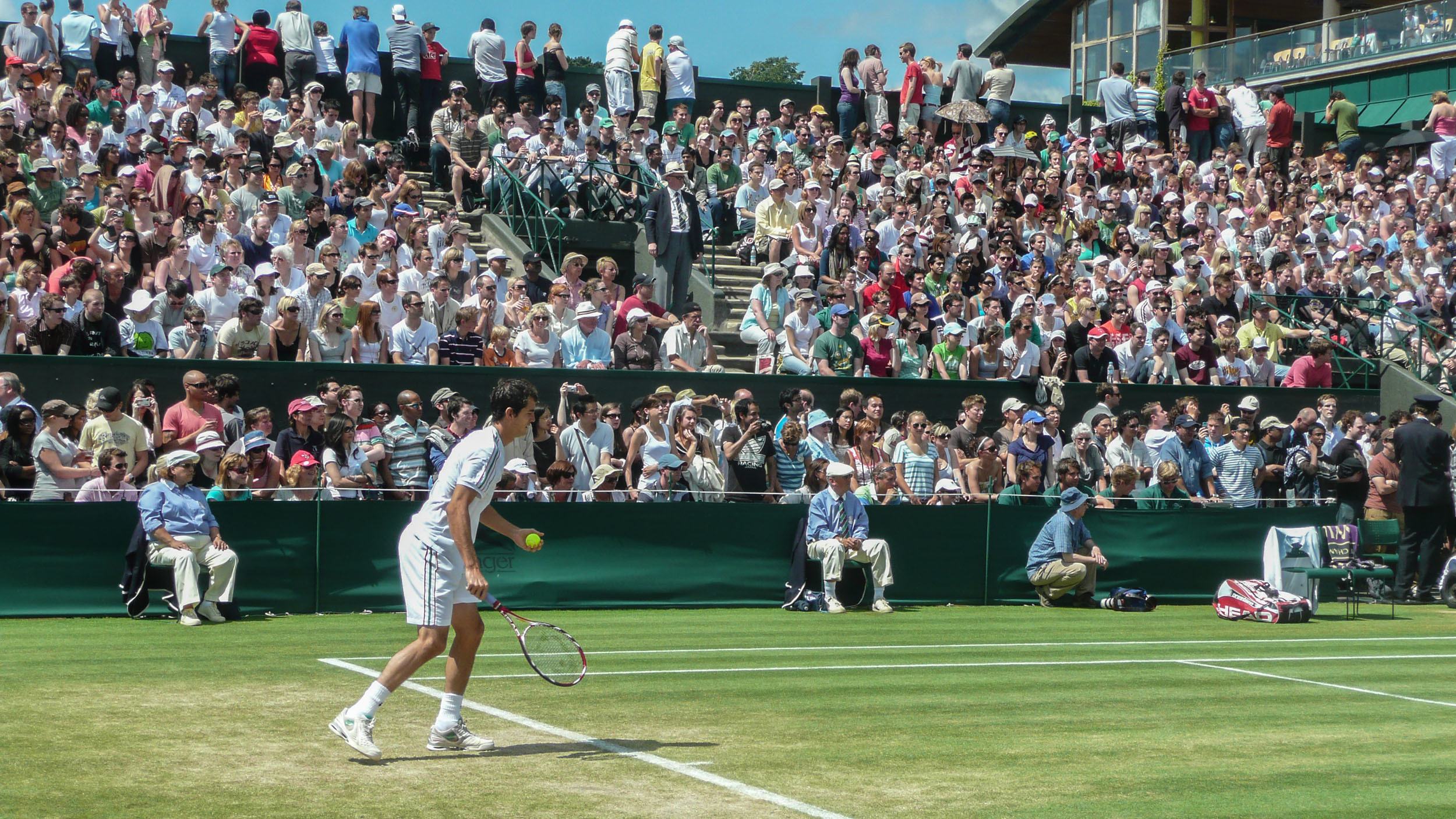 Professional tennis player at a Wimbledon outer court preparing to serve England United Kingdom