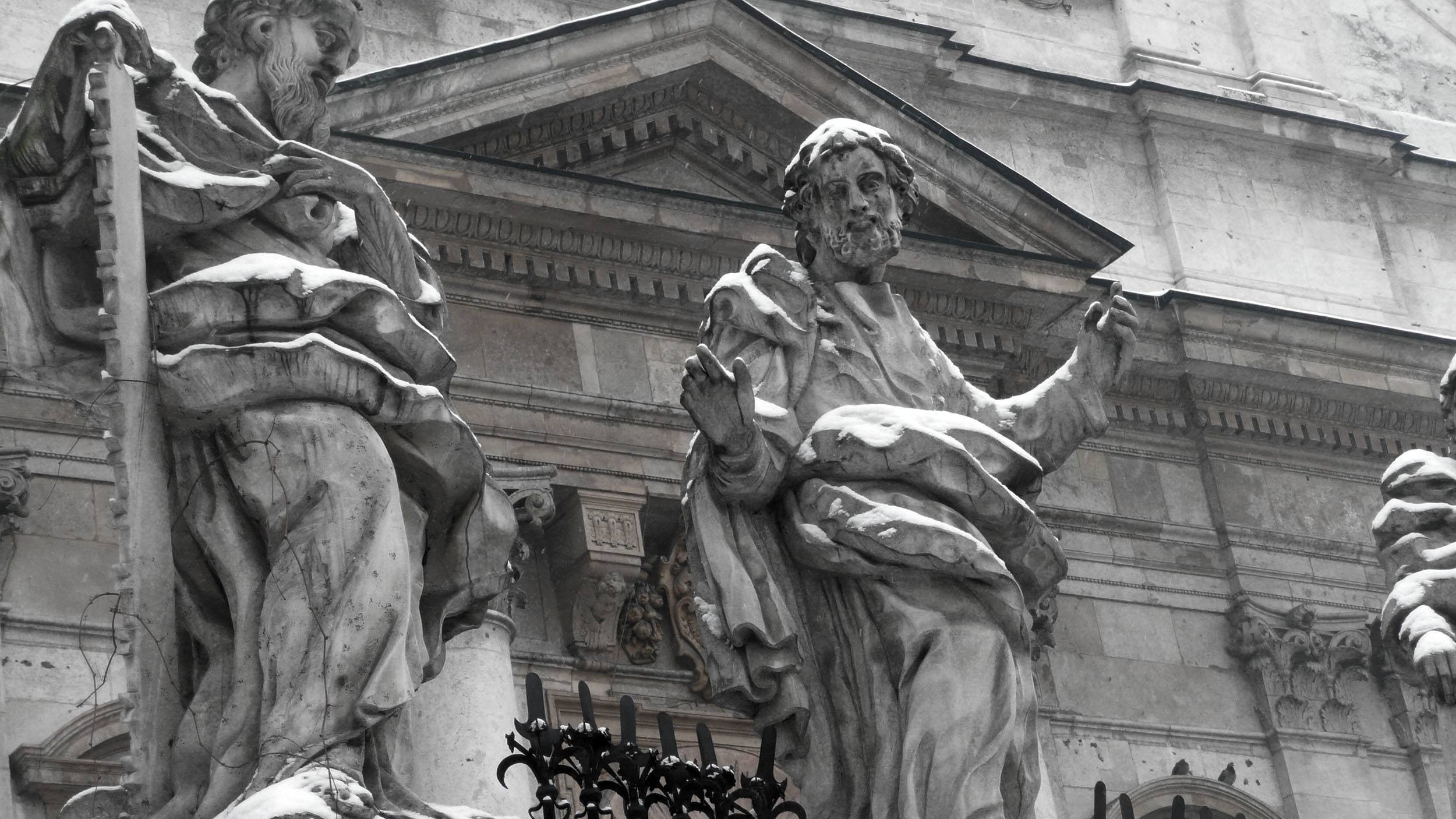 Statues covered in snow outside church in Krakow Poland