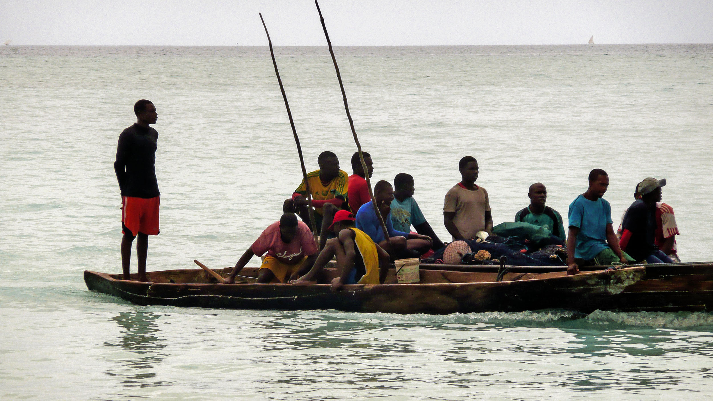 Tanzanian men sitting in a dhow near Nungwi Beach Zanzibar Tanzania