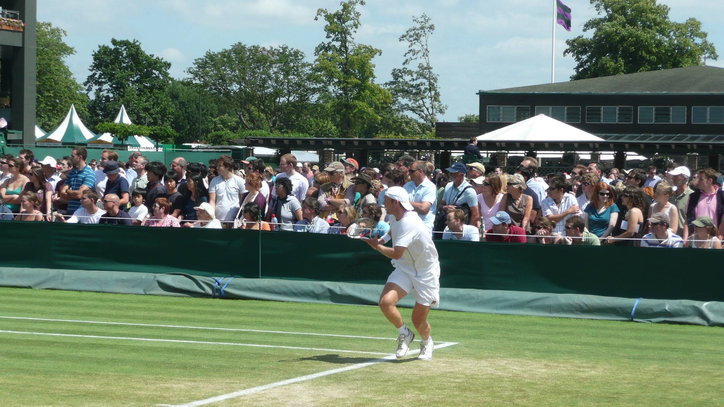 Tennis player running for the ball on a court at Wimbledon London England United Kingdom