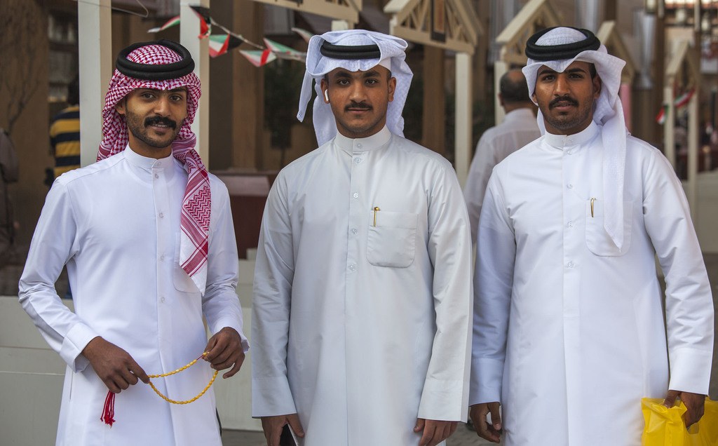 Three men wearing thobe in Souq Al-Mubarakiya Kuwait