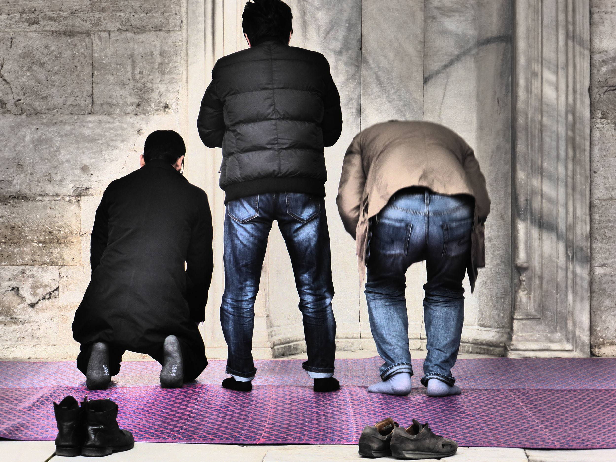 Turkish men standing following a prayer outside a mosque in Istanbul Turkey