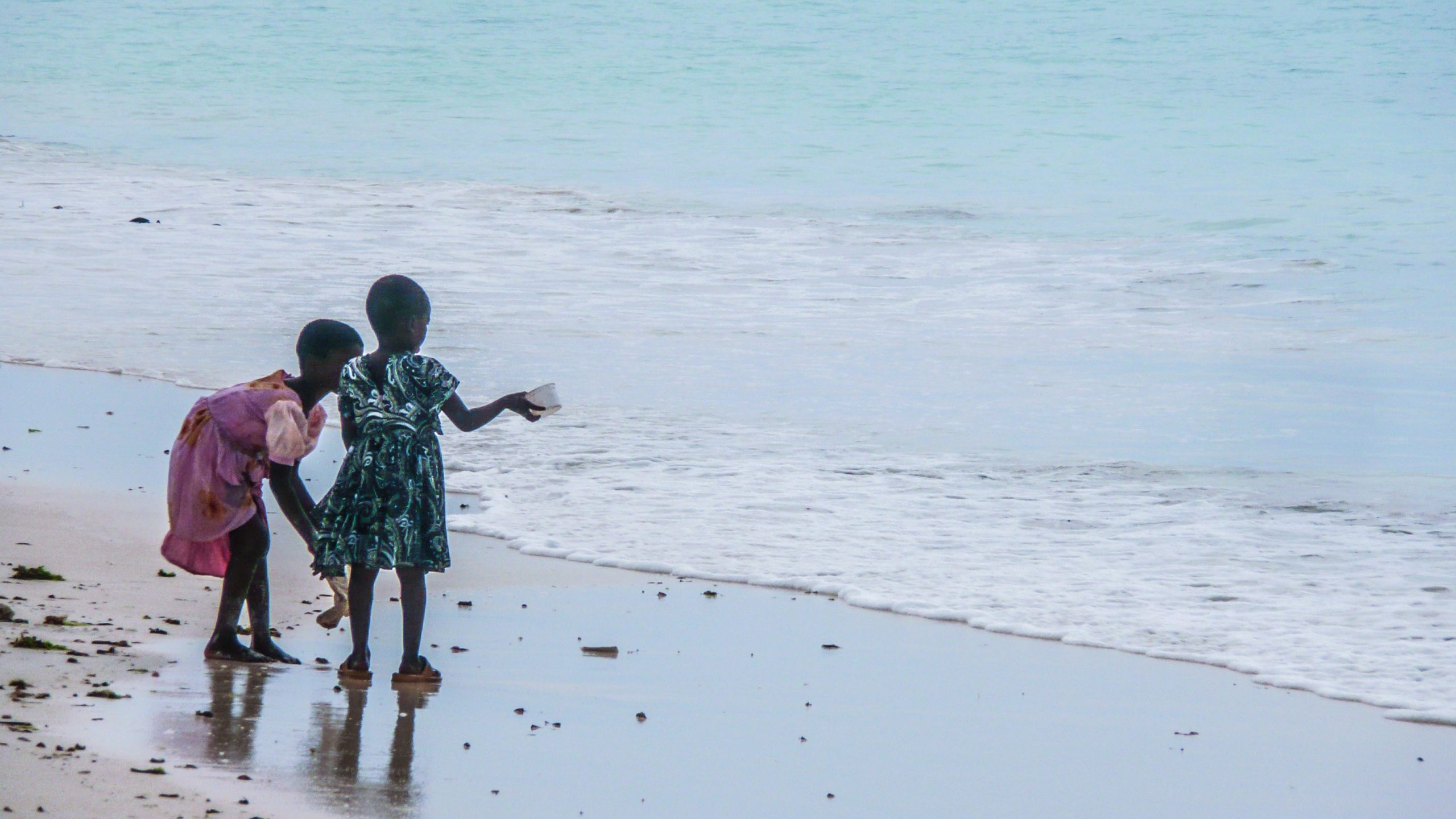 Two Tanzanian girls playing in the sand on Nungwi Beach Zanzibar Tanzania