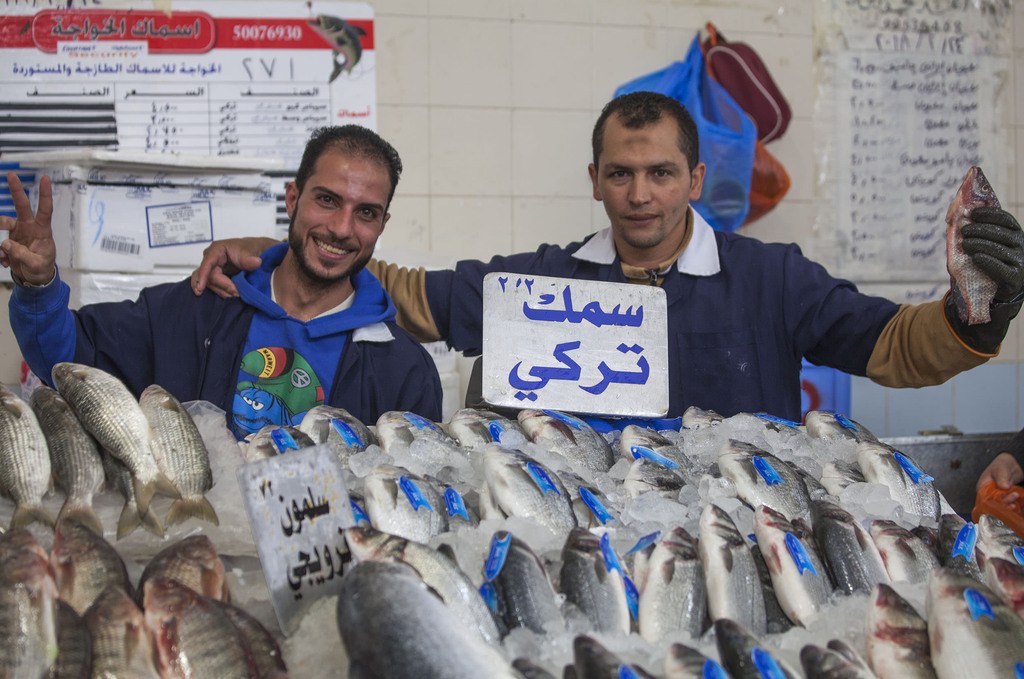 Two men behind a stall inside Central Fish Market in Kuwait