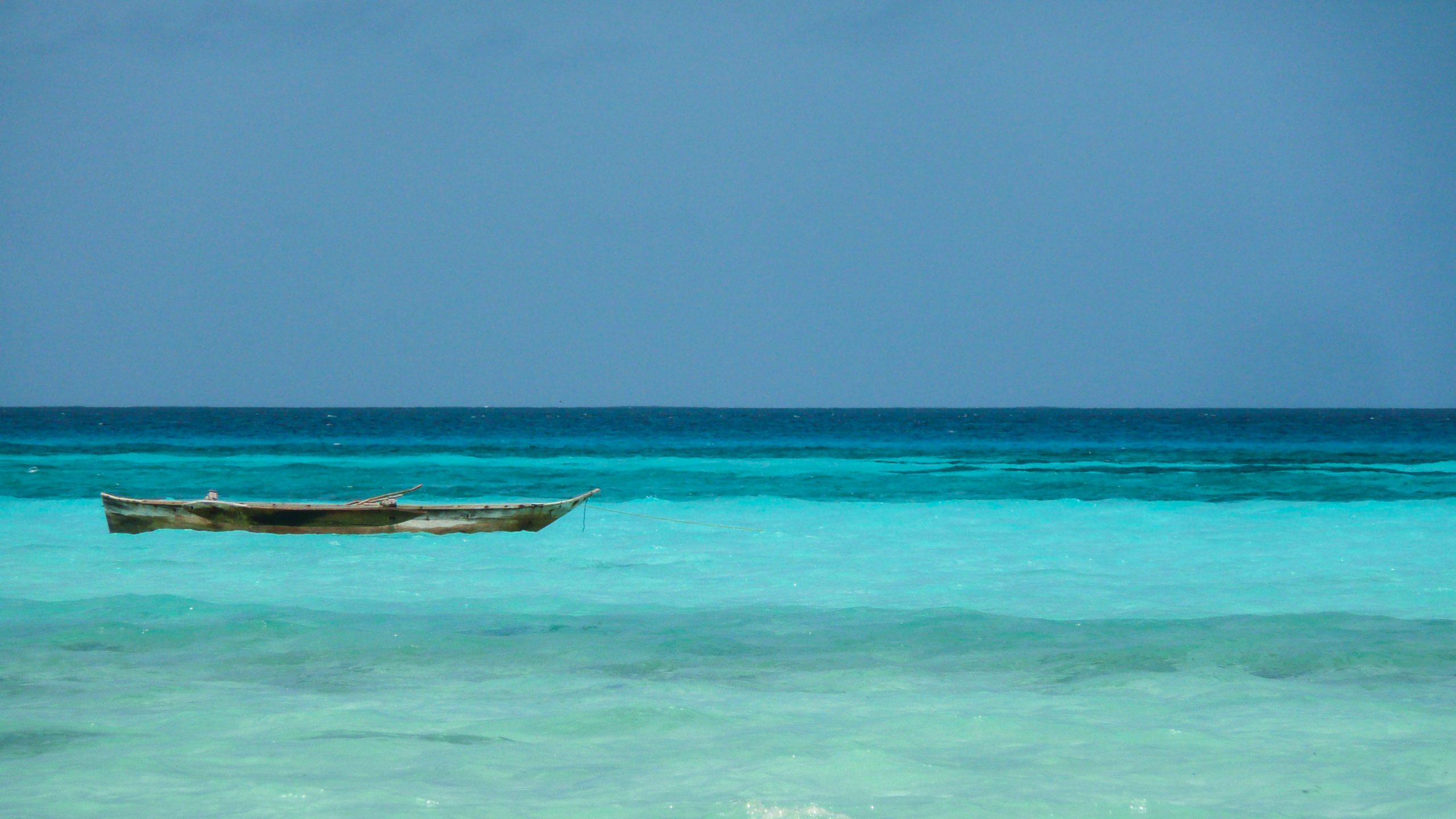 Unmanned dugout canoe floating on turquoise water near Zanzibar Tanzania