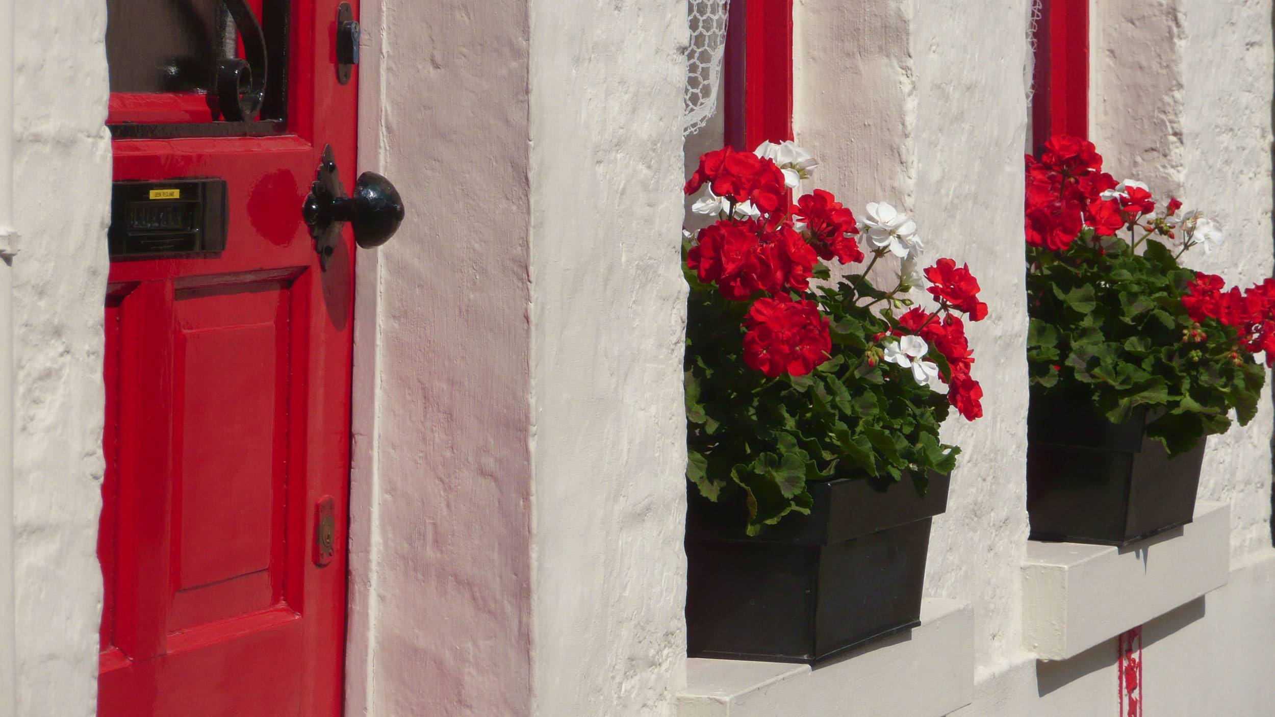 Window boxes overflowing with red and white geraniums in Bruges Belgium
