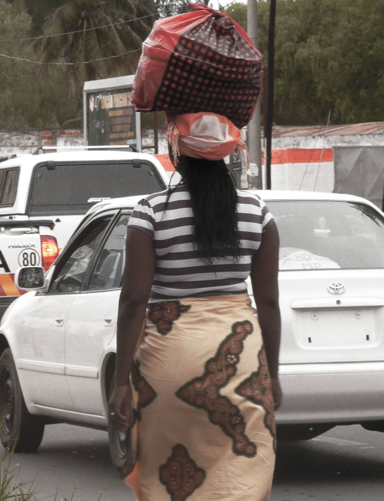 Woman carrying belongings on head in Maputo Mozambique